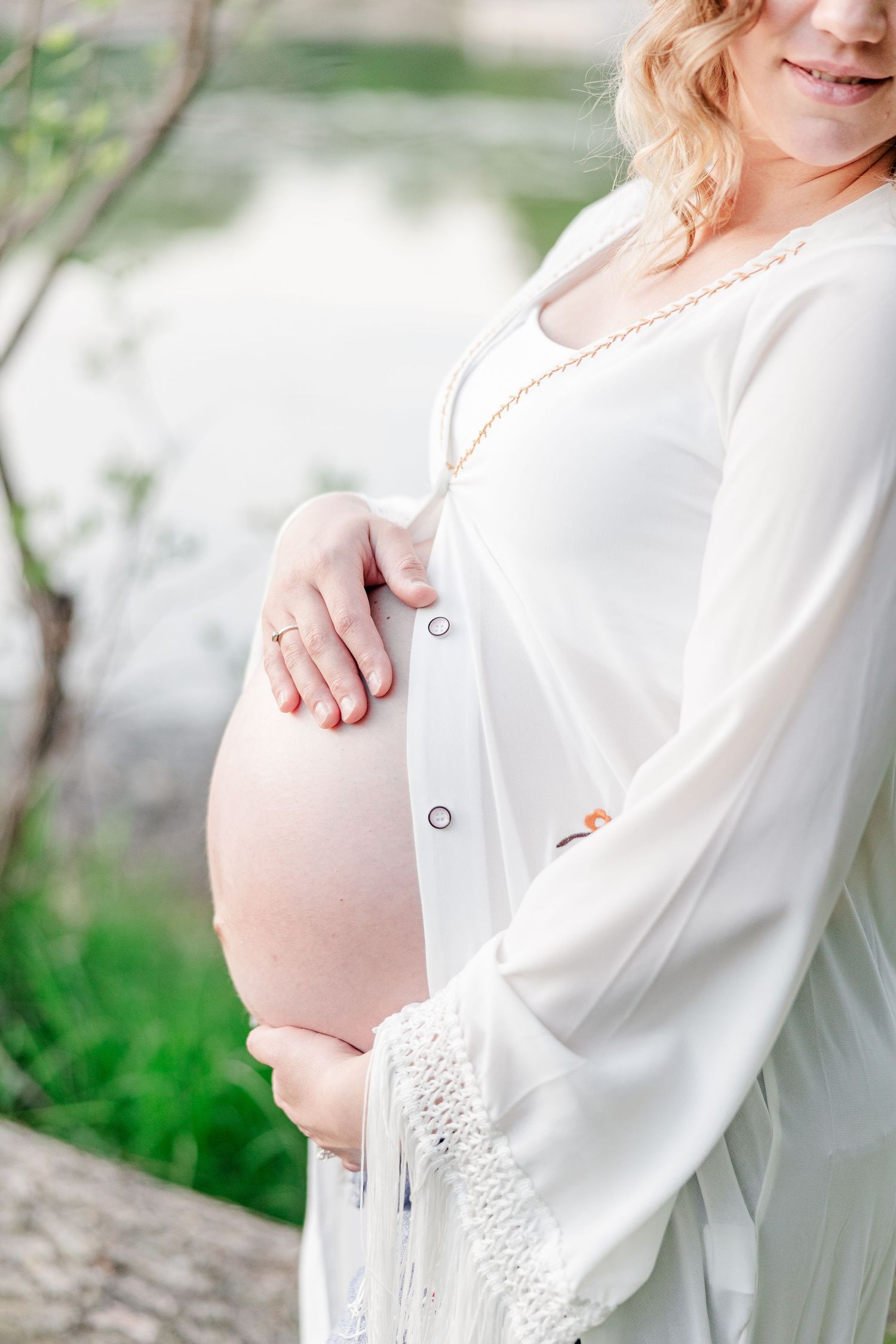 Close-up maternity portrait of mother holding baby bump during a Crystal Lake maternity session.
