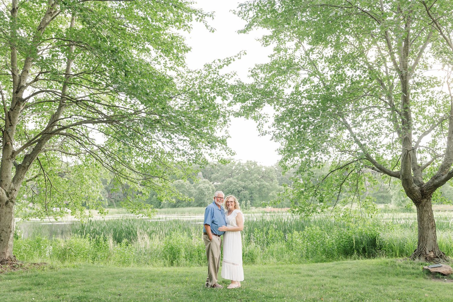 Grandparents standing together in summer greenery during an extended family portrait session in Crystal Lake