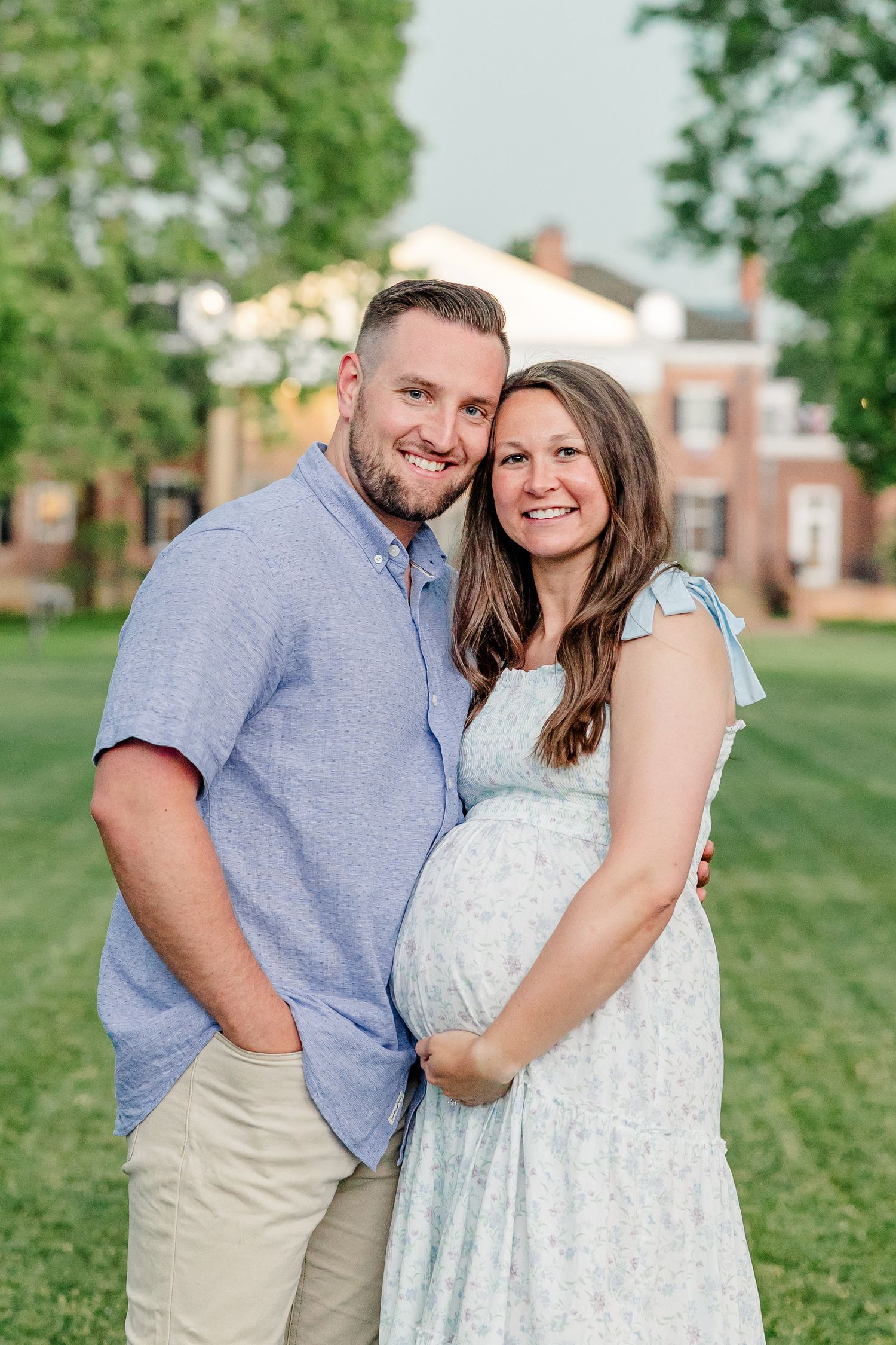 Expecting parents smiling together with the Cantigny mansion in the background