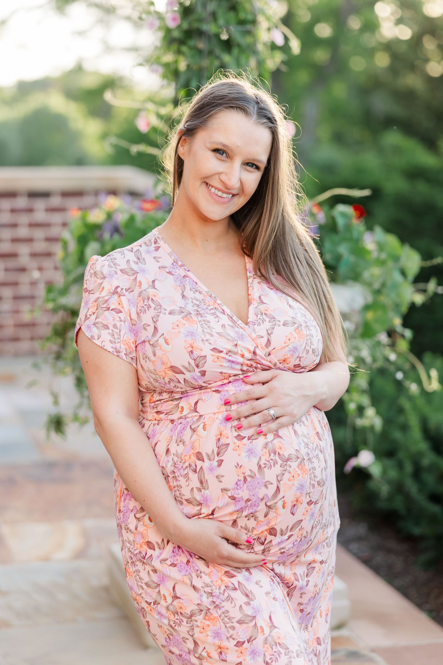 Smiling solo maternity portrait in the summer gardens at Cantigny Park in Wheaton Illinois