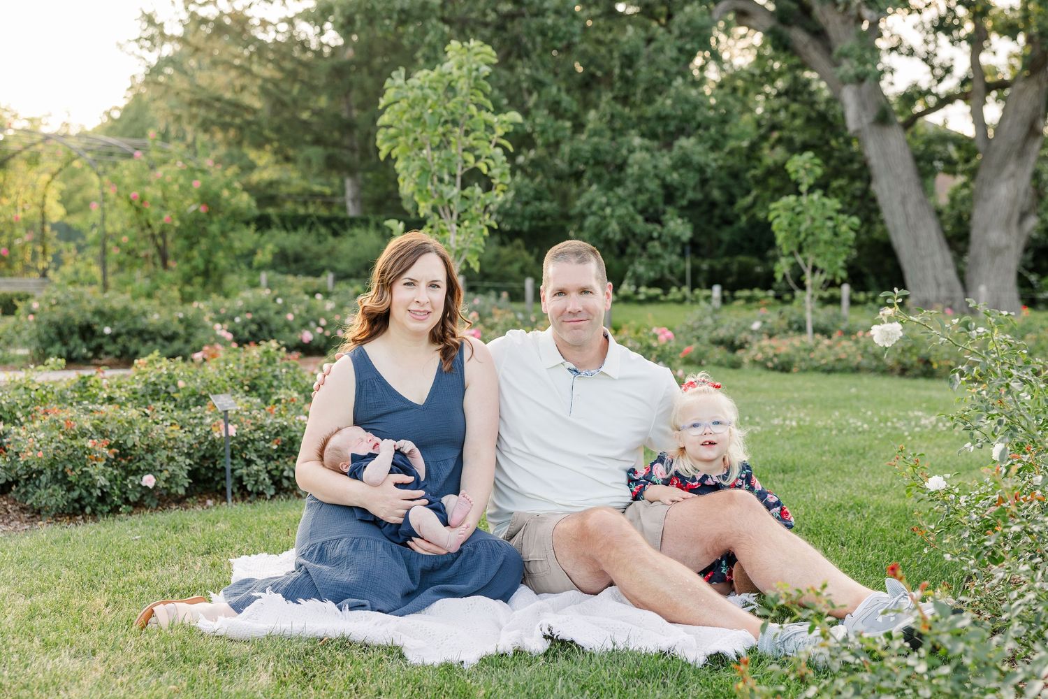 Hilary, Andrew, Caroline, and newborn Lincoln smiling together during their Cantigny Park family session.