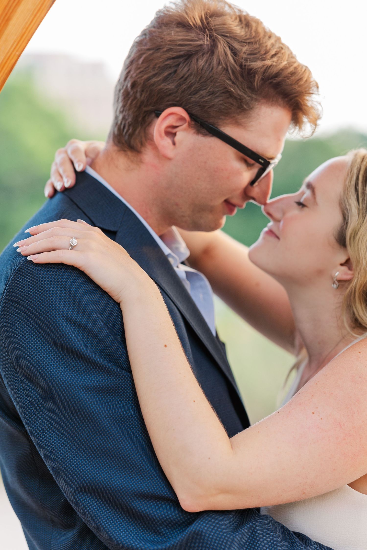 Close up of Elizabeth's engagement ring as Elizabeth and Joe hug each other under the Lincoln Park Honeycomb Pavillion