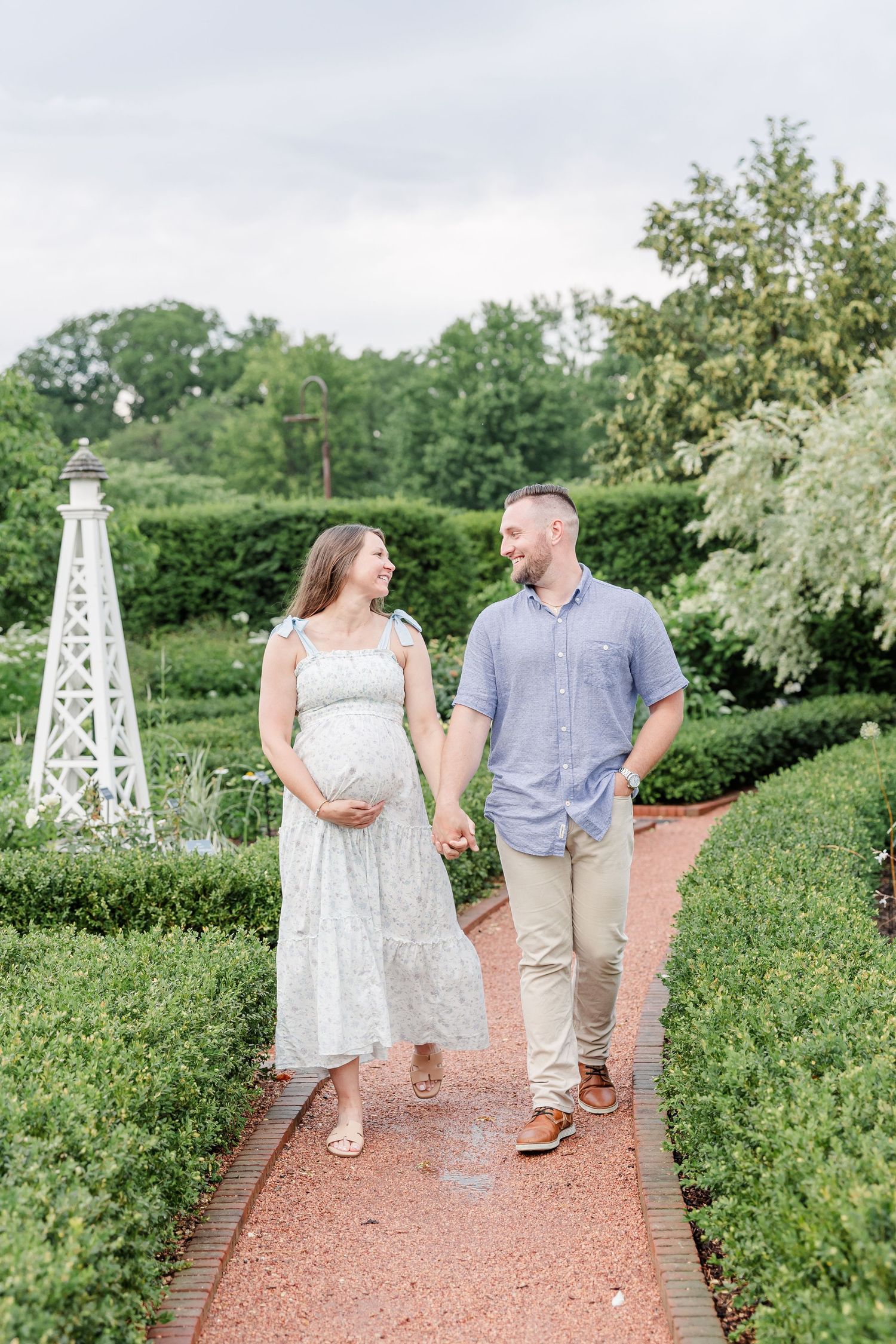 Expecting parents walking together through the gardens during a Wheaton maternity session
