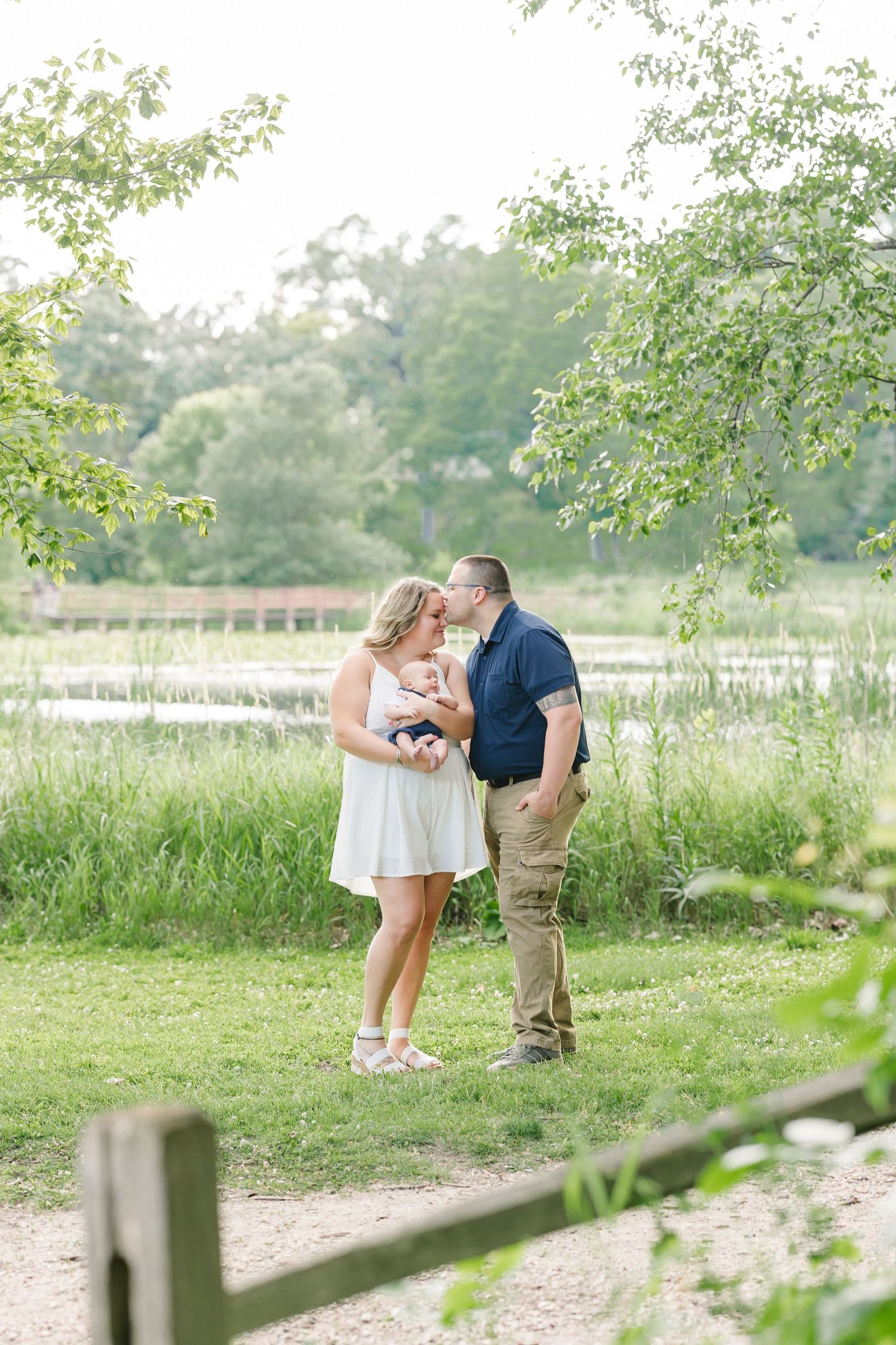 Parents sharing a sweet kiss during an extended family photo session at Veterans Acres Nature Center in Crystal Lake
