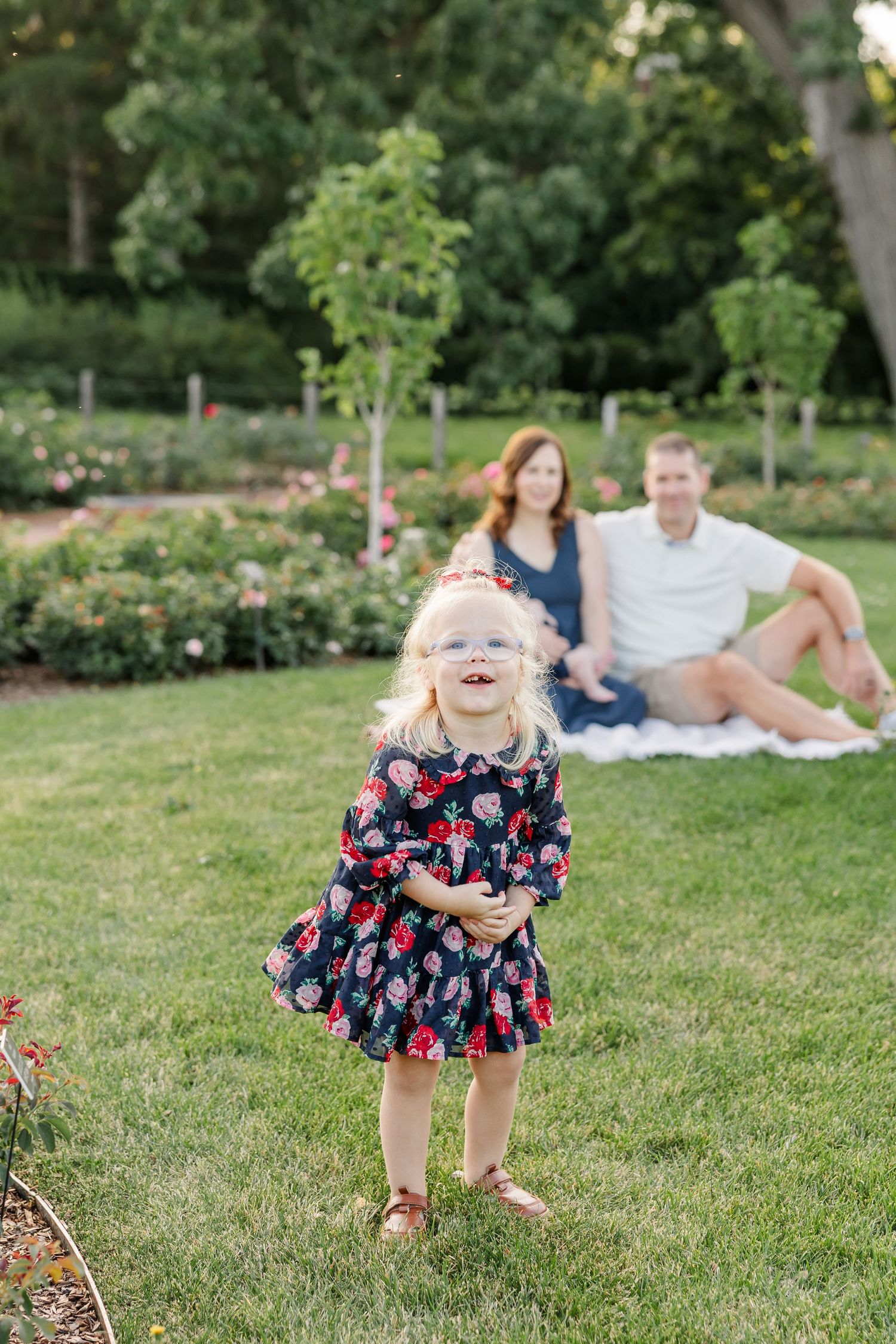 Caroline laughing in the foreground as Hilary and Andrew sit with baby Lincoln behind her.