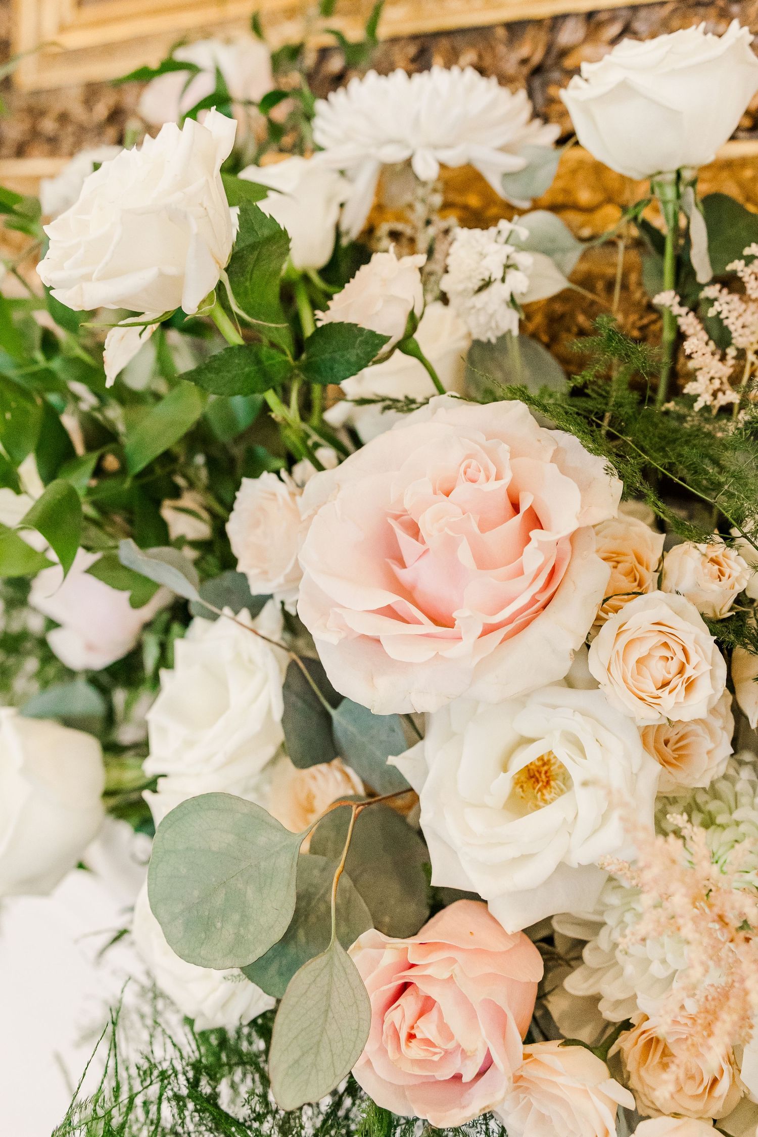 Romantic floral arrangement featuring white and pink roses with eucalyptus leaves.