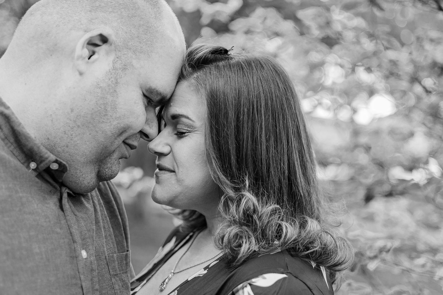 Black and white romantic portrait with soft natural lighting and bokeh background.