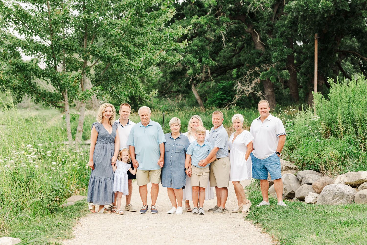 A group photo of family members dressed in coordinating blues and whites standing together outdoors.