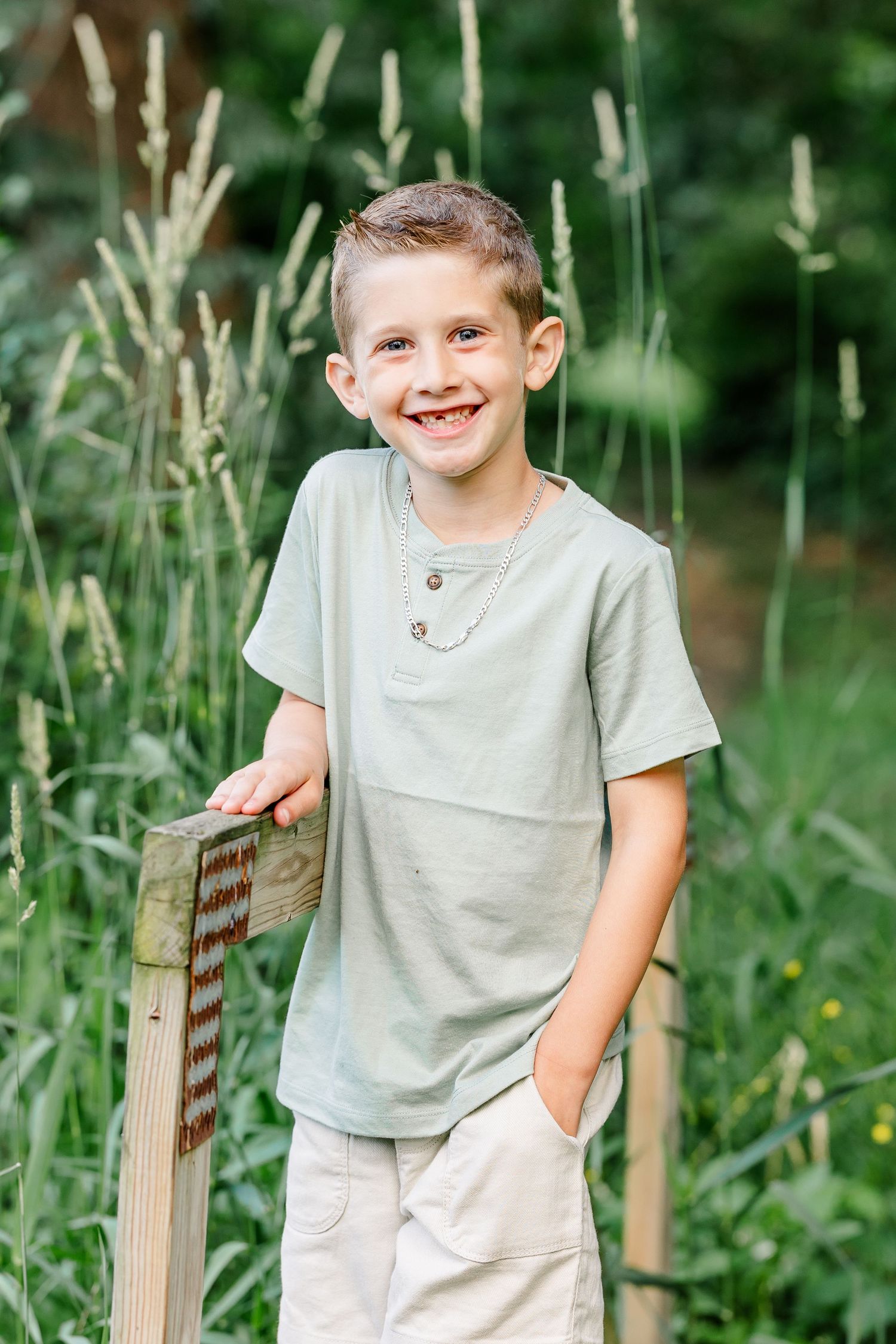 Young boy smiling for a portrait during a Crystal Lake family photo session at Shamrock Hills Park.