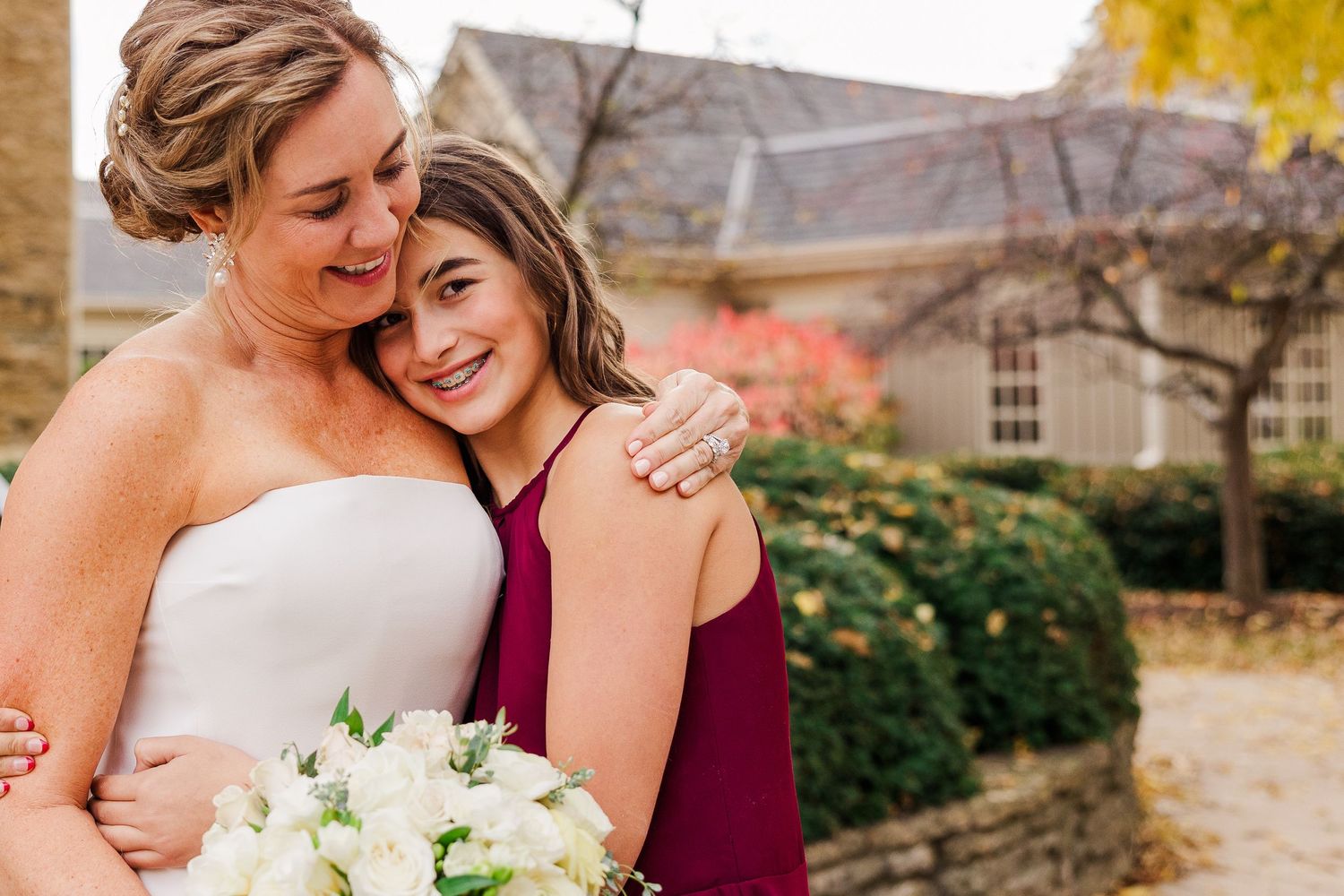 Emotional embrace between two figures during outdoor wedding celebration.