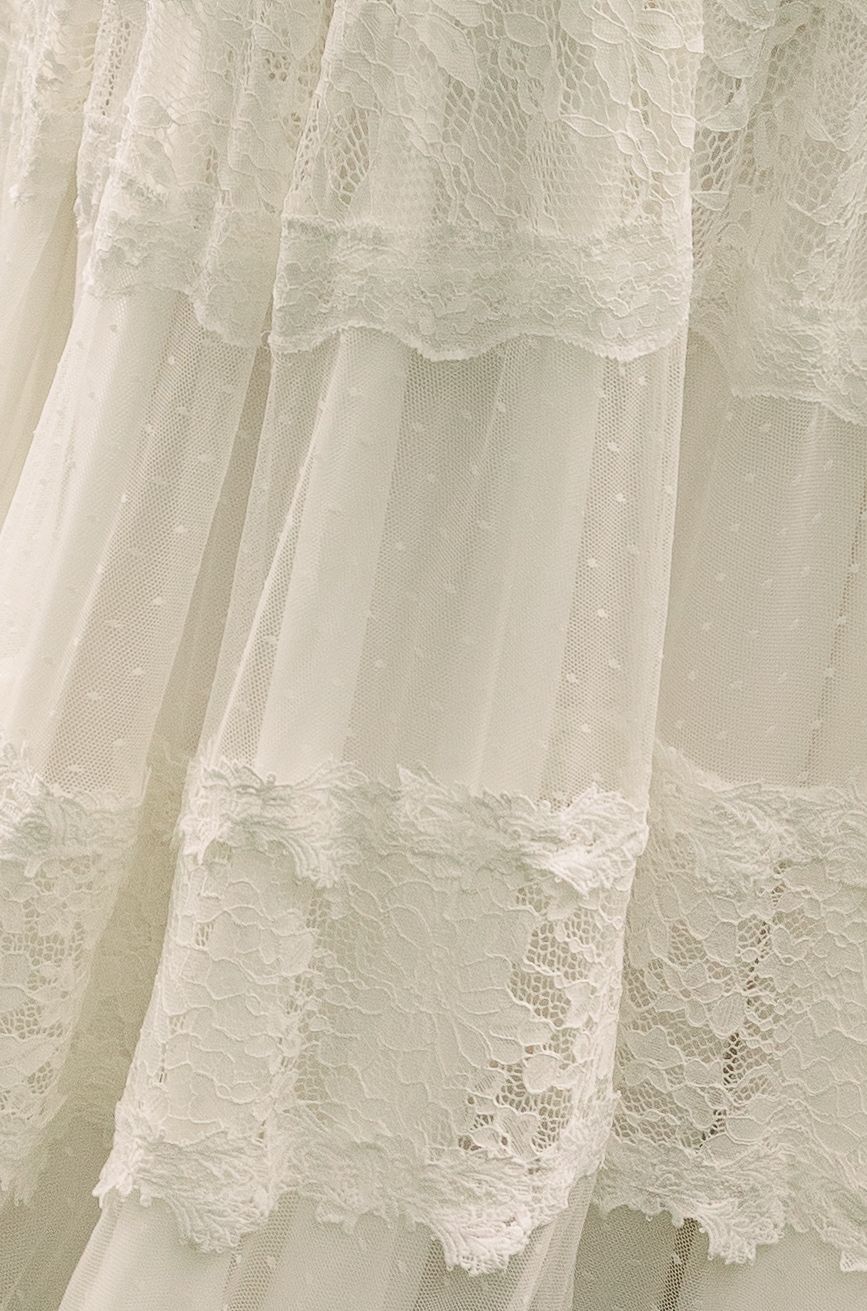 Close-up of delicate white lace details on a vintage-style wedding dress.