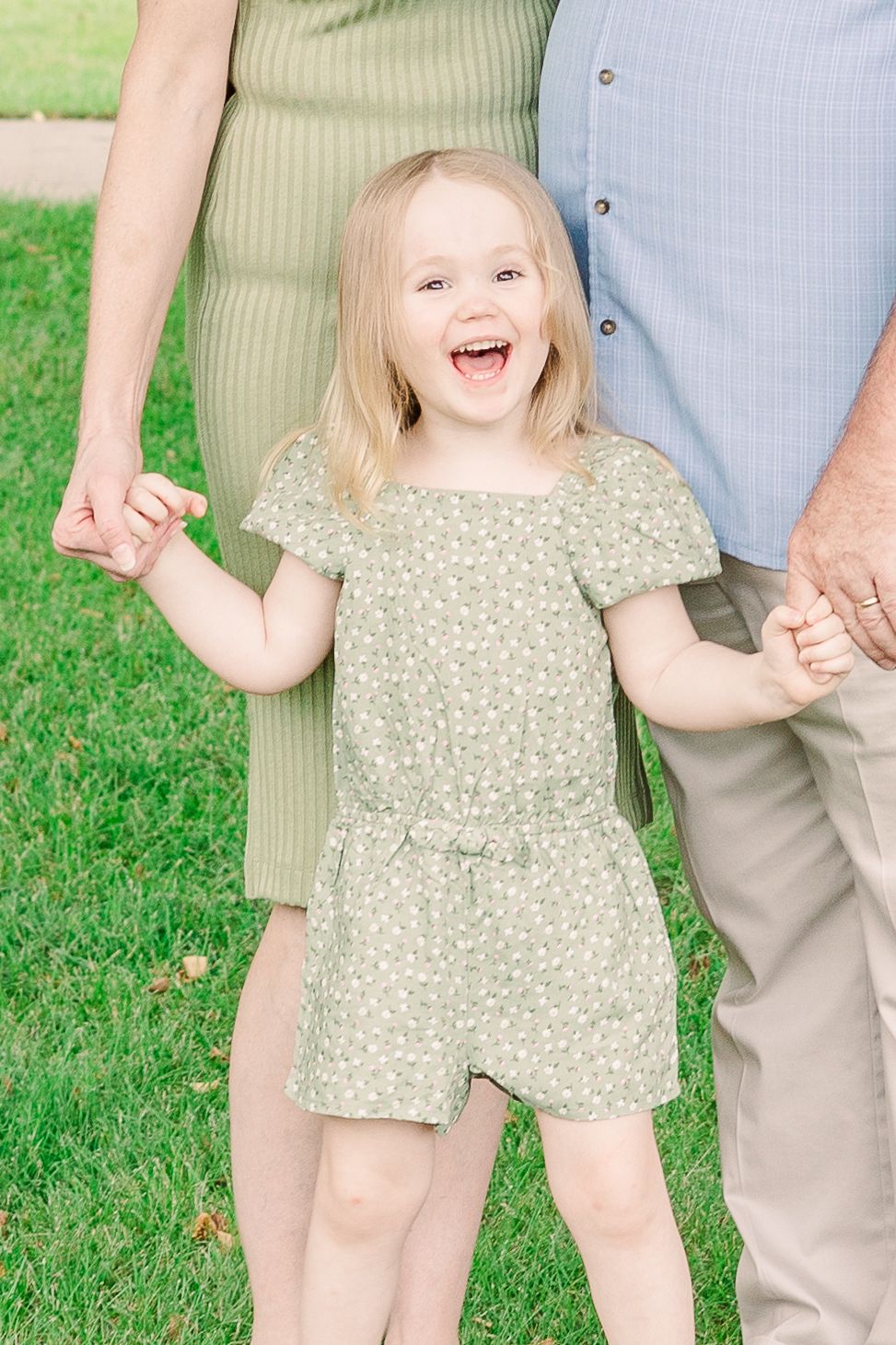 Joyful moment captured outdoors on a sunny day with green grass background.