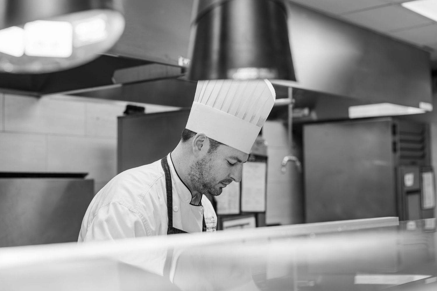 Black and white Beacon Hill senior living branding photo in Lombard, Illinois featuring chef in kitchen