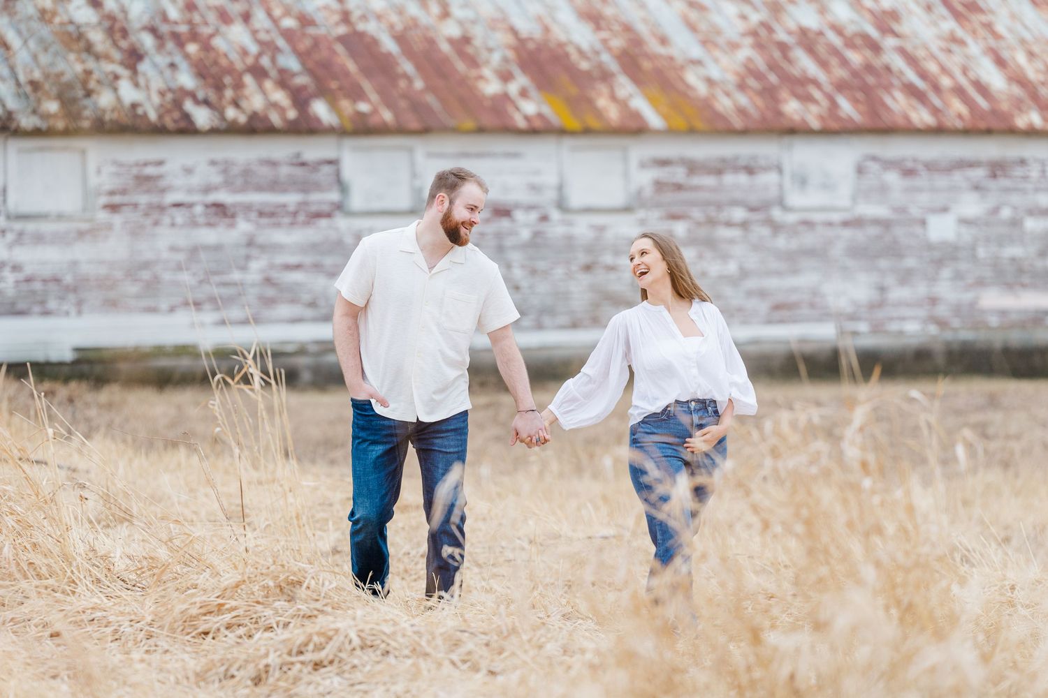 Couple walking during pregnancy announcement photos at Sands Main Street Prairie in Cary, Illinois
