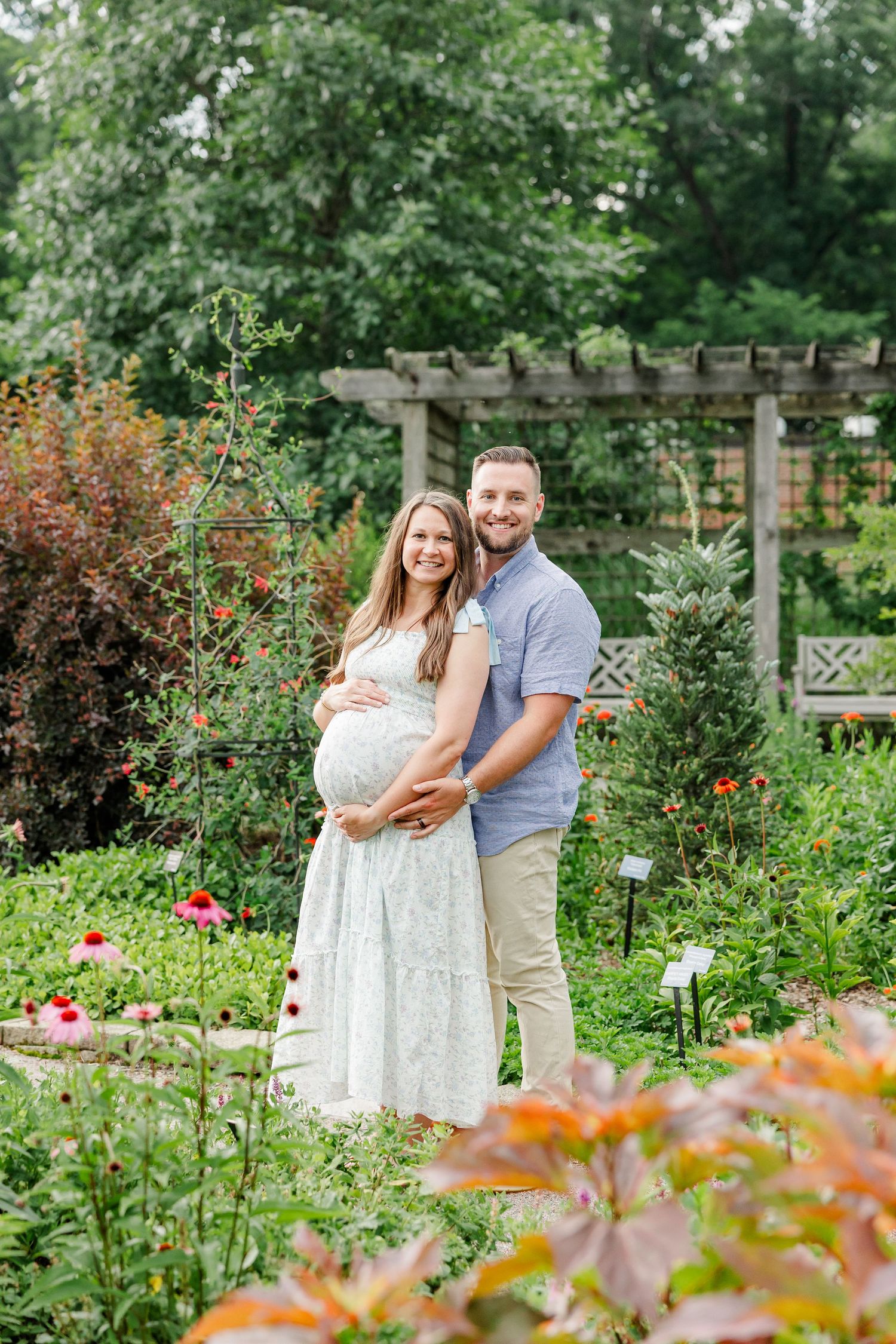 Expecting parents standing together in the summer gardens at Cantigny Park