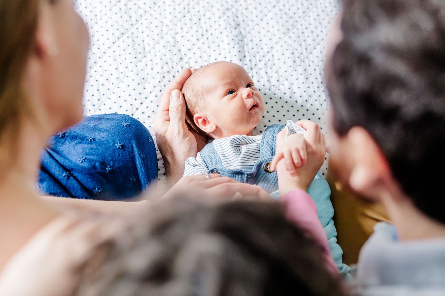 Family admiring newborn son during in-home lifestyle newborn session in Crystal Lake, Illinois