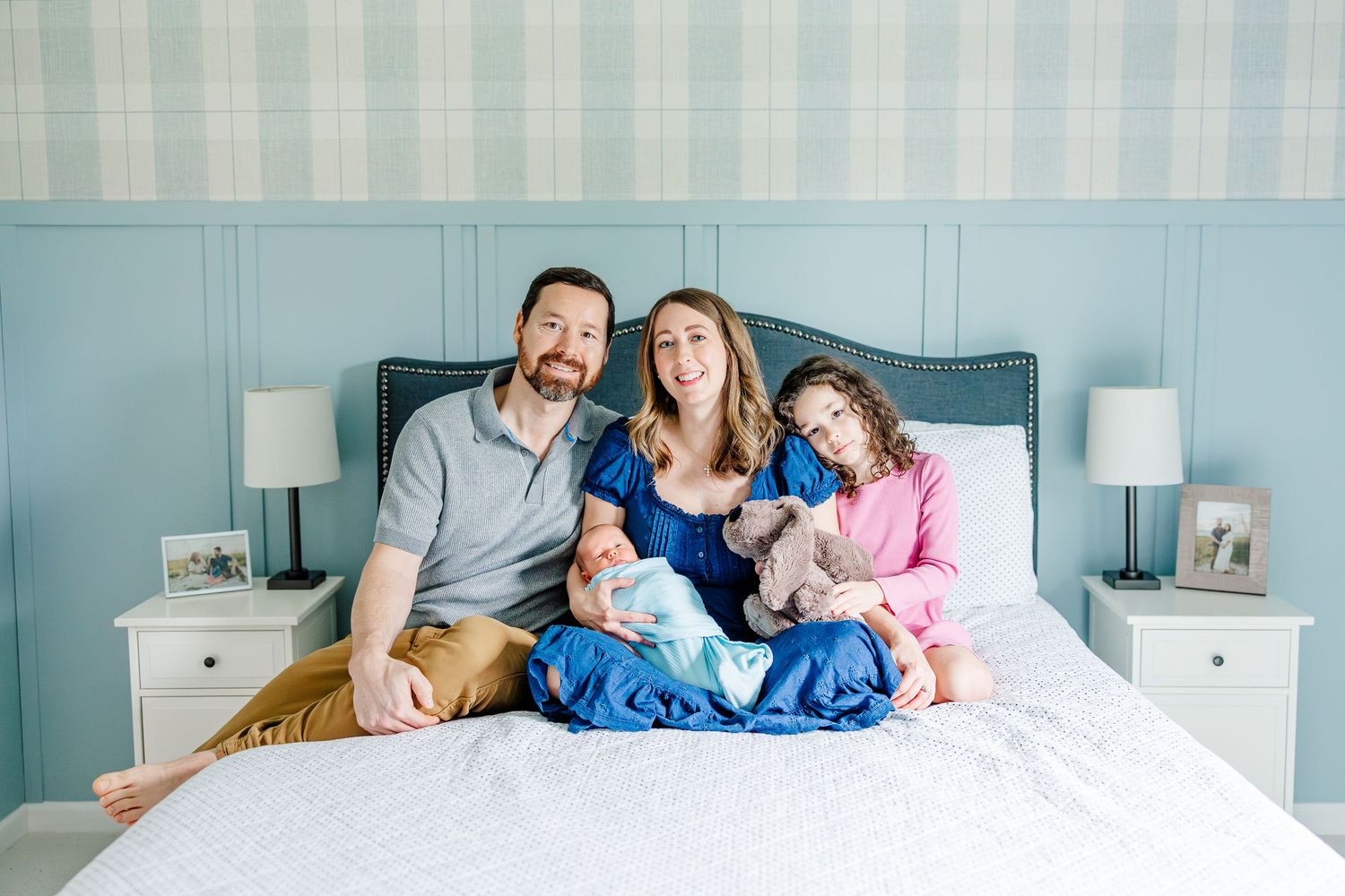 Family of four on bed during bright lifestyle newborn session in Crystal Lake, Illinois