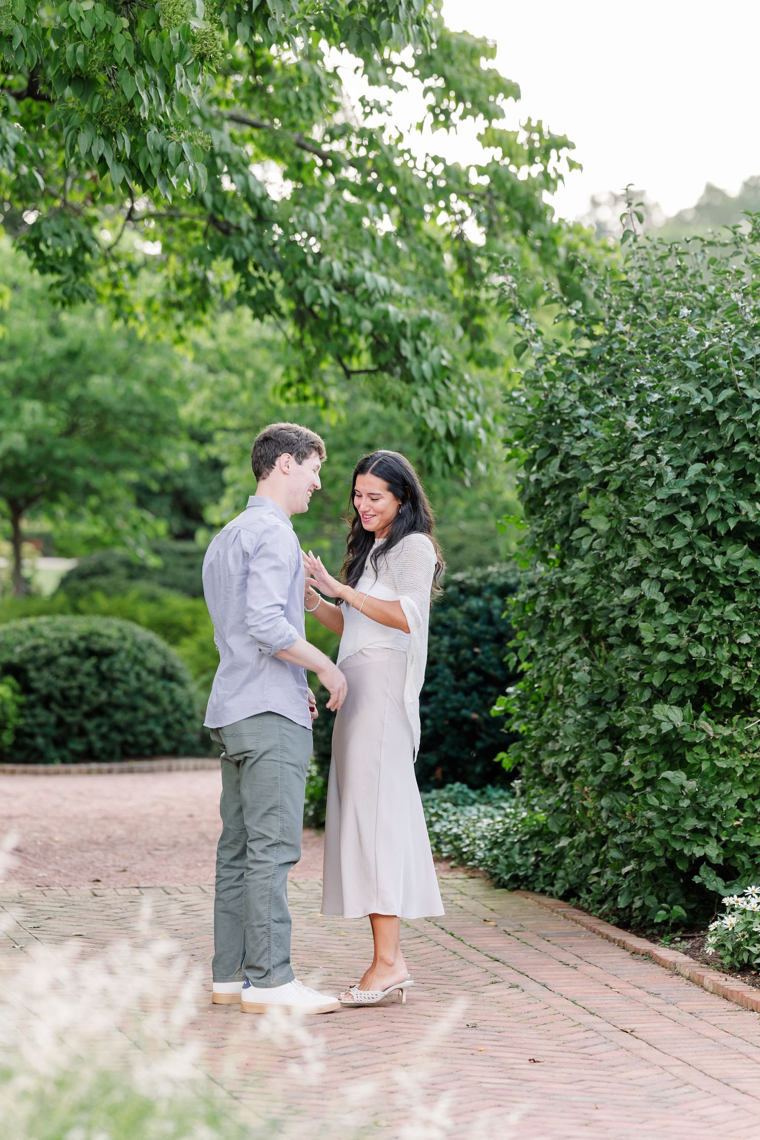 Alysia admires her new engagement ring while standing with Jack at Cantigny Park.