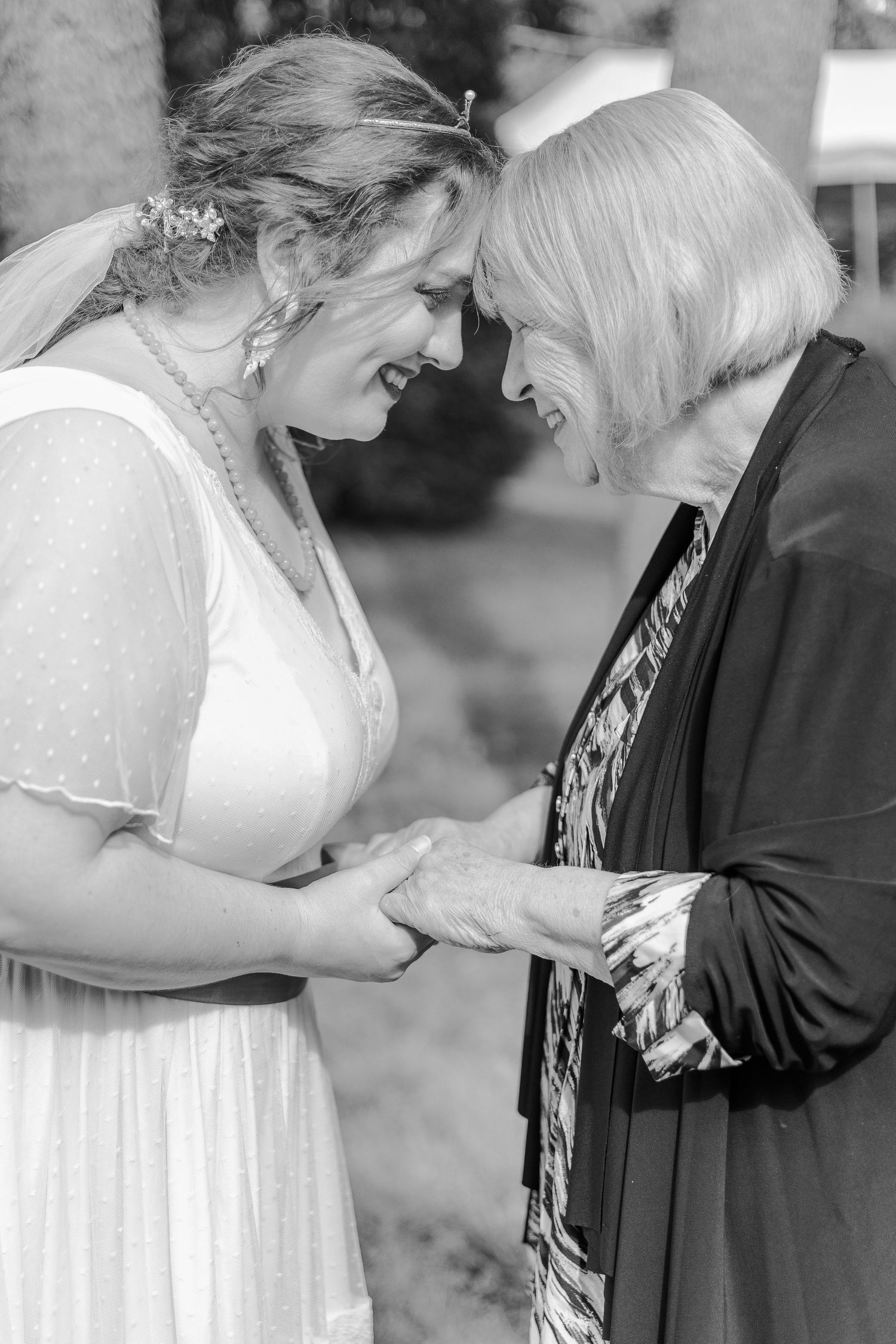 A tender black and white moment shared between two people at a wedding.