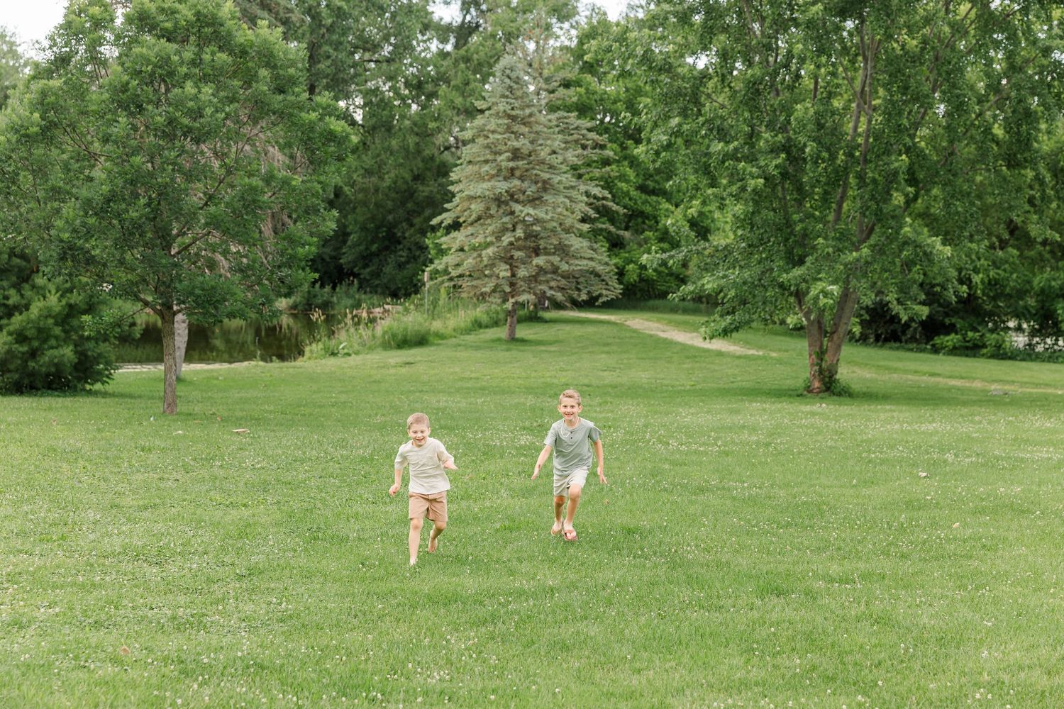Two young brothers walking through the park during a candid family photography session in Crystal Lake.