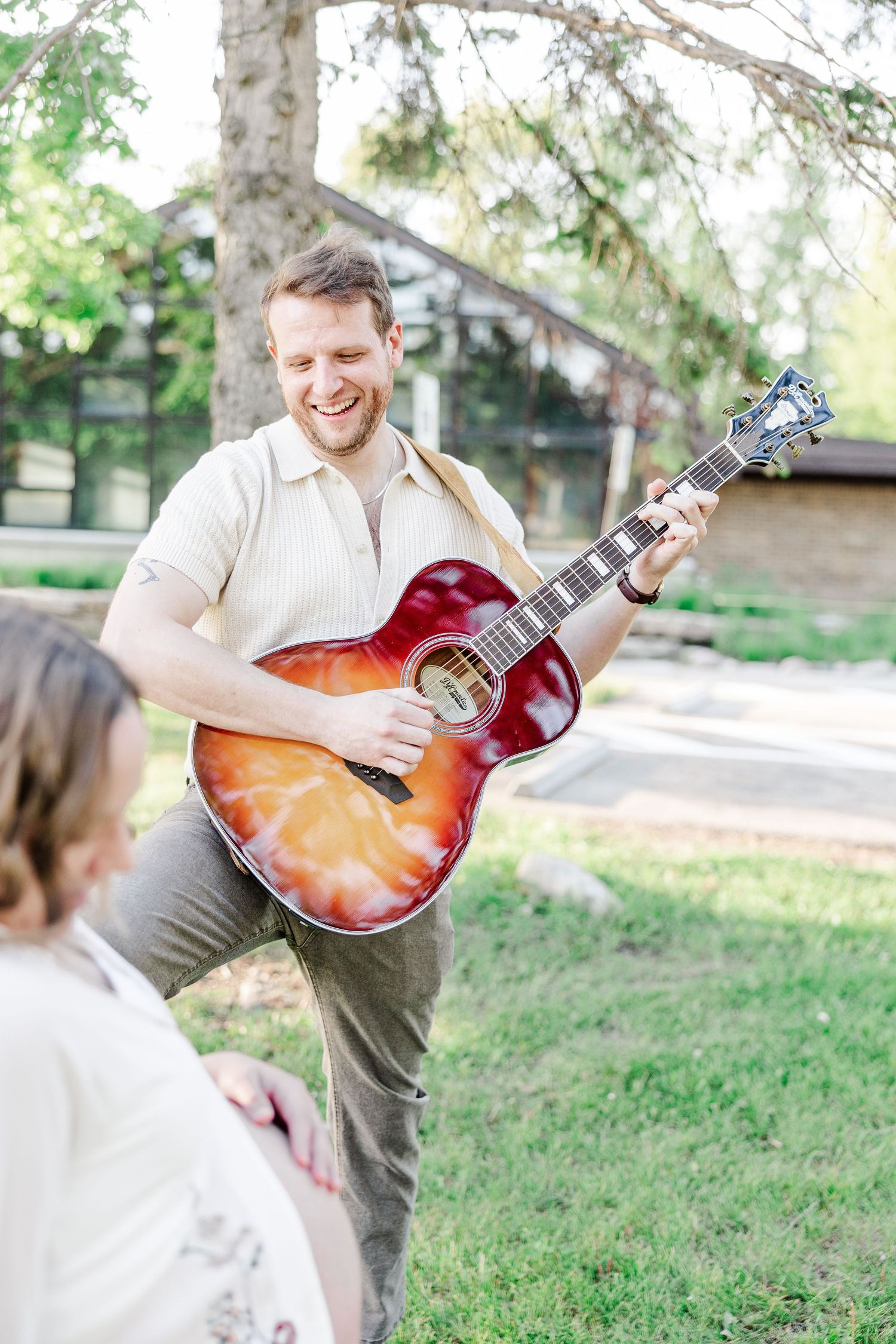 Father playing guitar during an outdoor maternity session in Crystal Lake, Illinois.