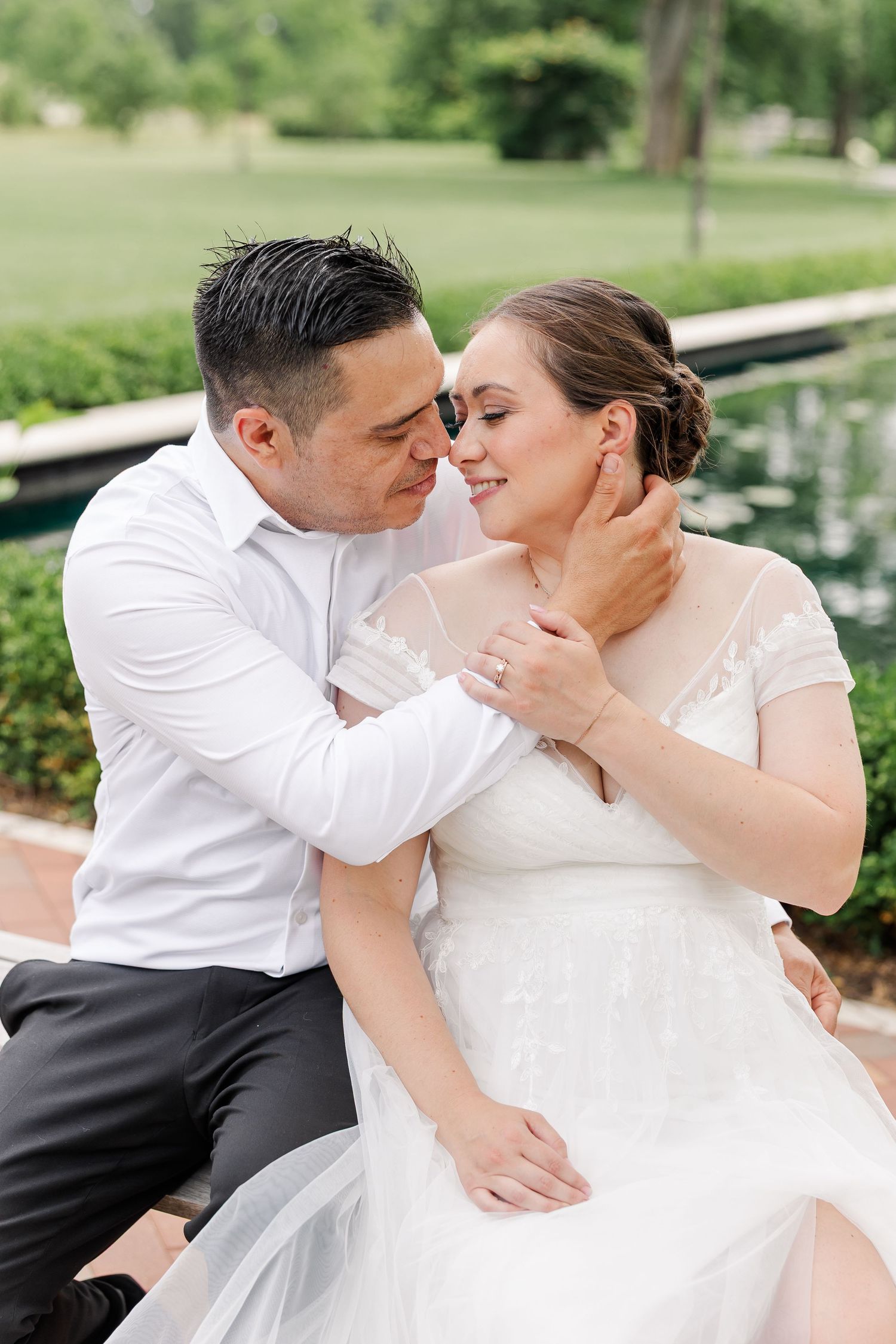 Rafael gently holding Monika’s face as they share a quiet moment together on a garden bench.
