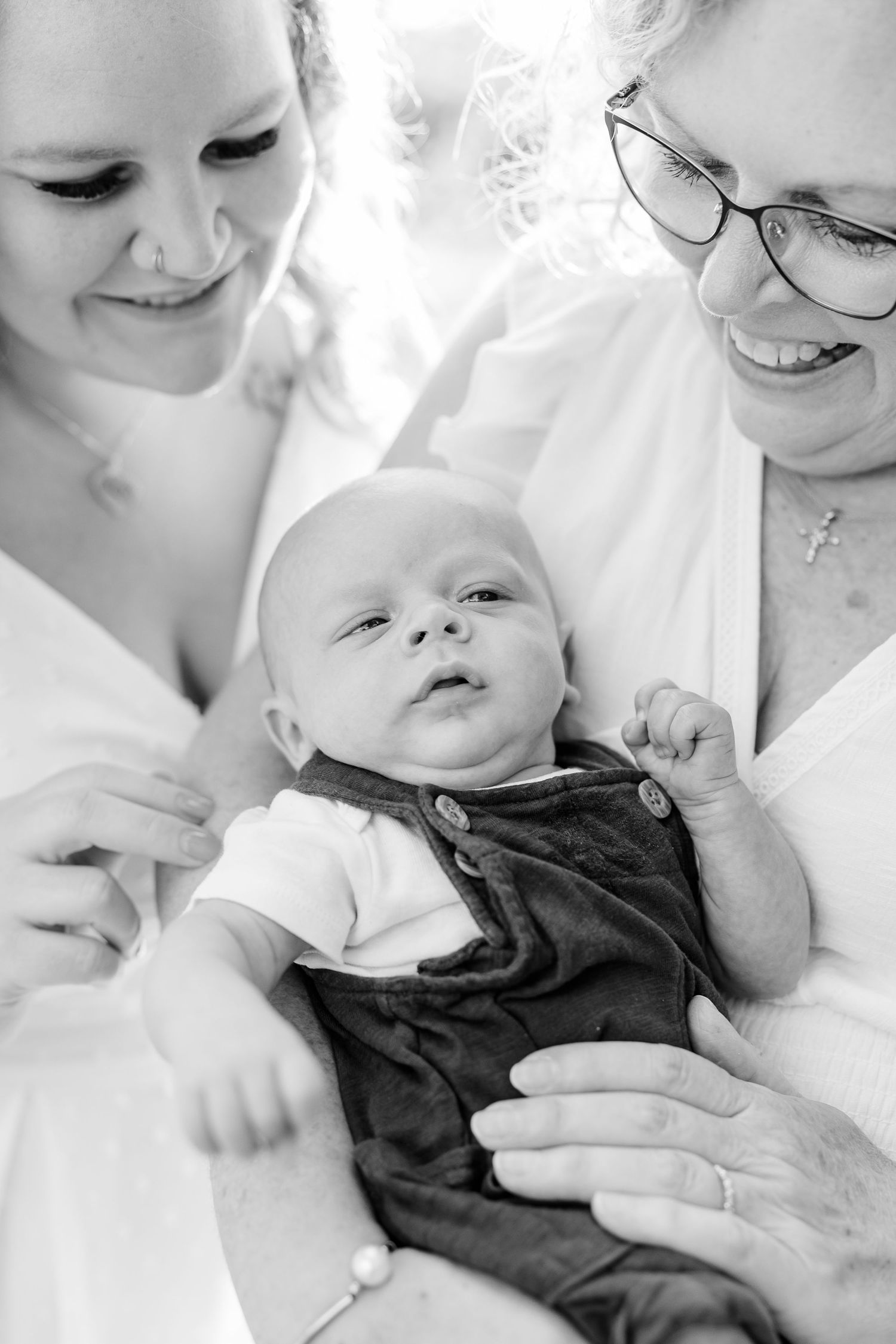 Black and white baby photo with parents holding their baby boy during an outdoor extended family session in Crystal Lake