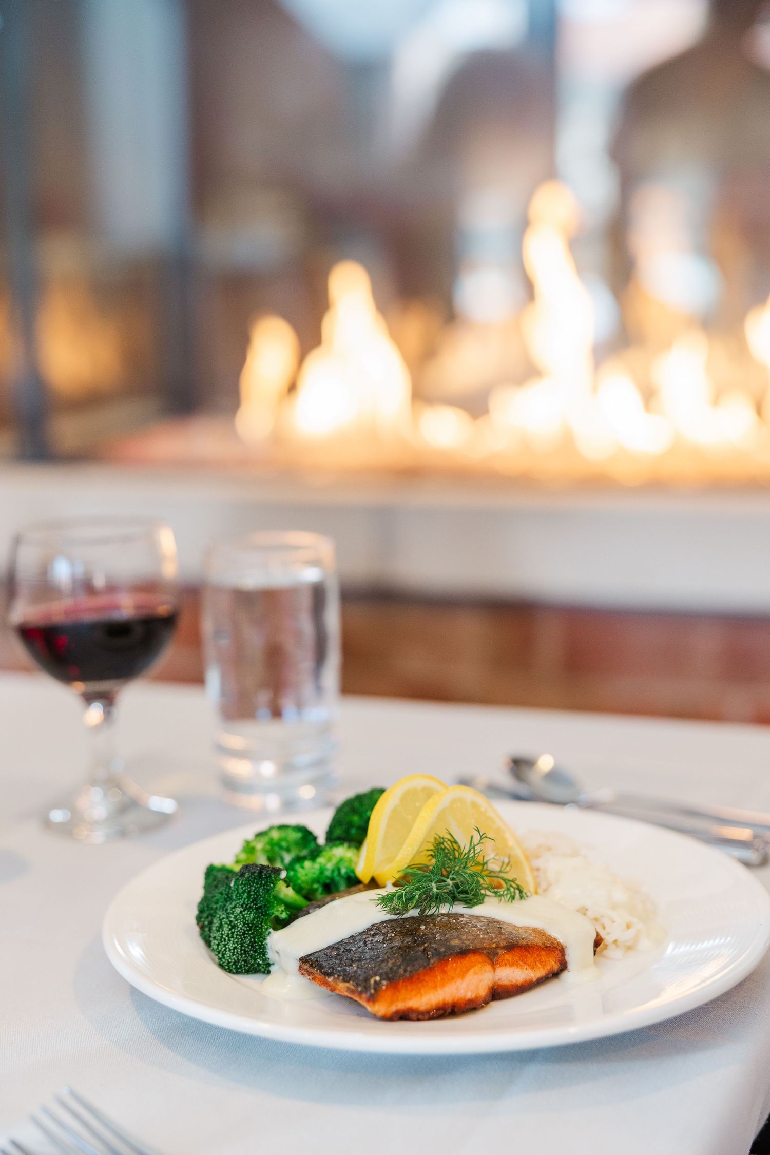Beacon Hill senior living branding photo in Lombard, Illinois featuring plated dinner by fireplace