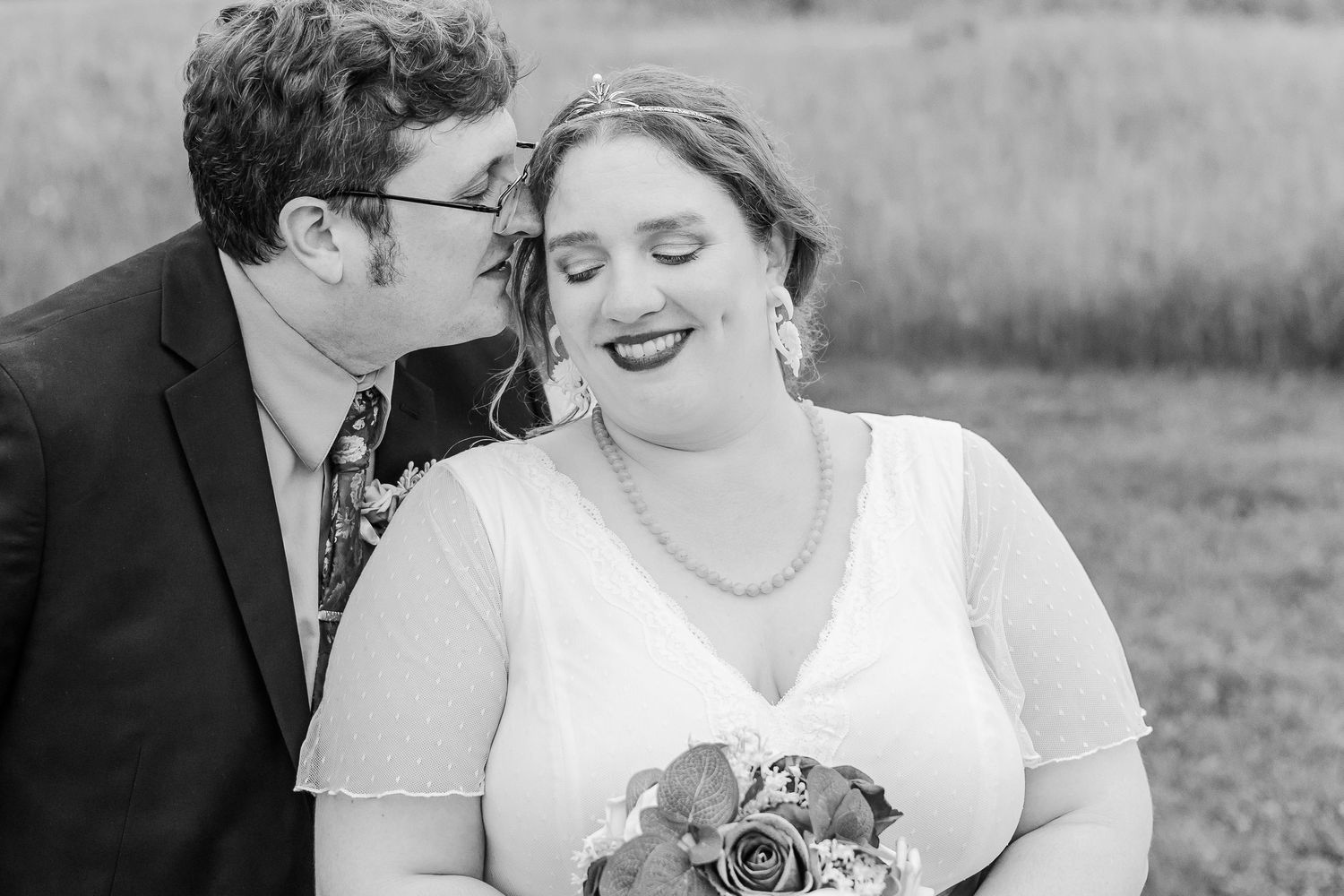 A tender black and white wedding moment captured with a joyful smile and intimate whisper.