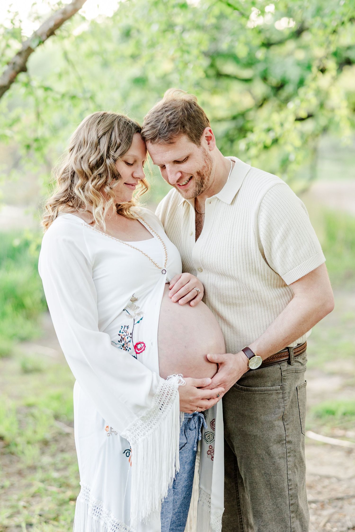 Close-up maternity portrait of expecting parents holding baby bump at Veterans Acres Nature Preserve.