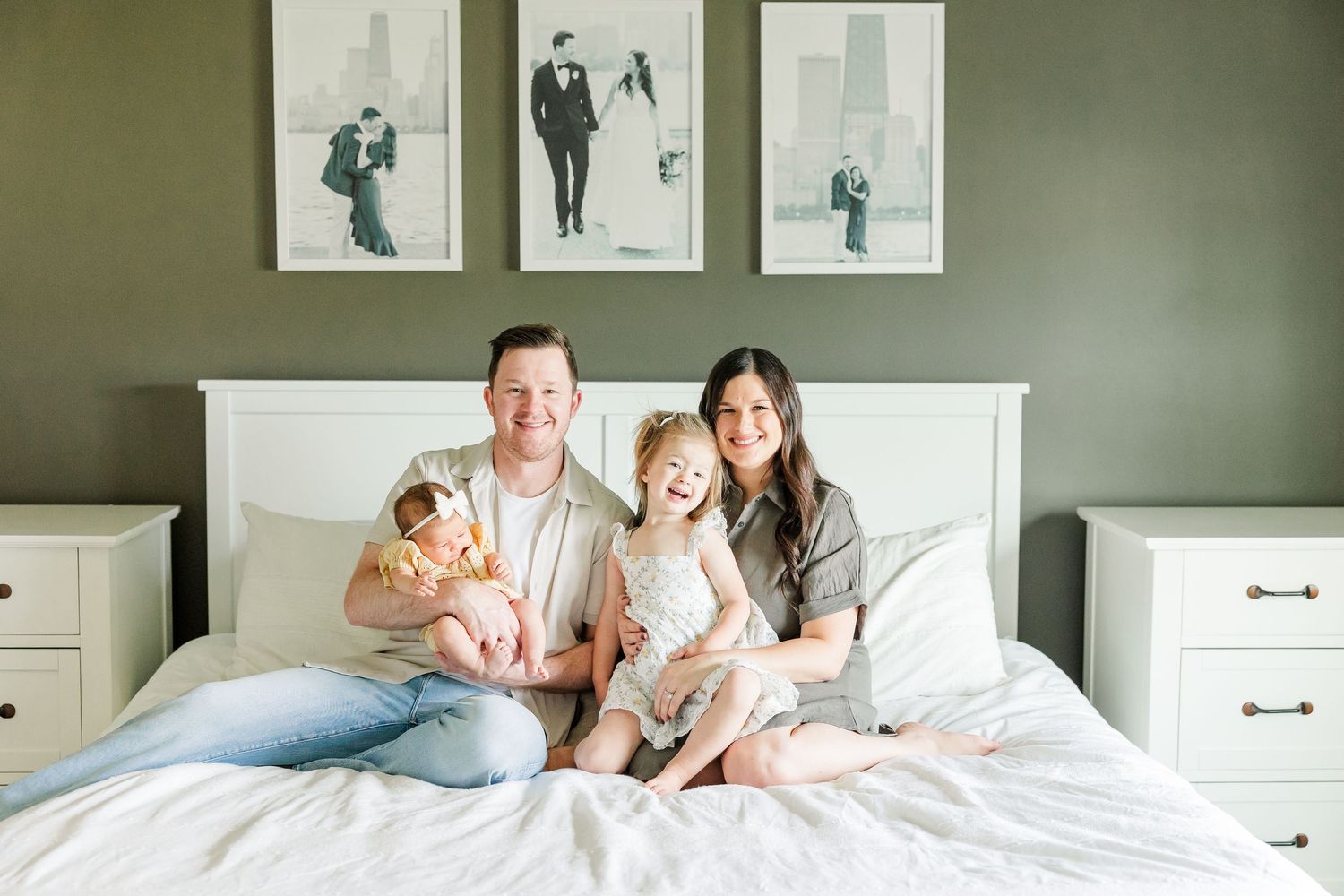 Parents with big sister and newborn baby girl on the bed during an in-home lifestyle newborn session in Huntley IL