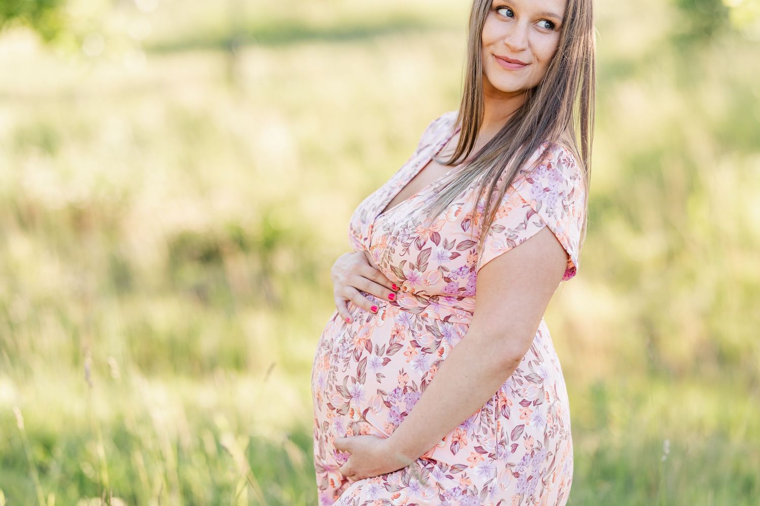 Solo maternity portrait in a floral dress during a summer Cantigny maternity session in Wheaton Illinois