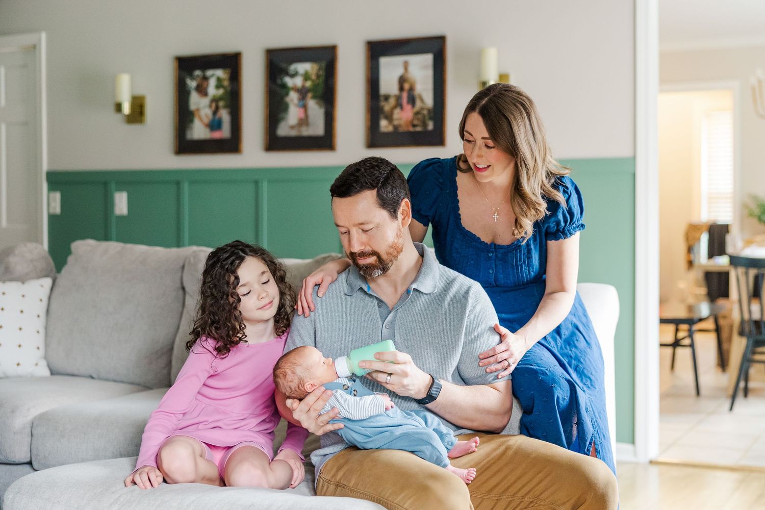 Family of four cuddles on couch during in-home lifestyle newborn session in Crystal Lake, Illinois