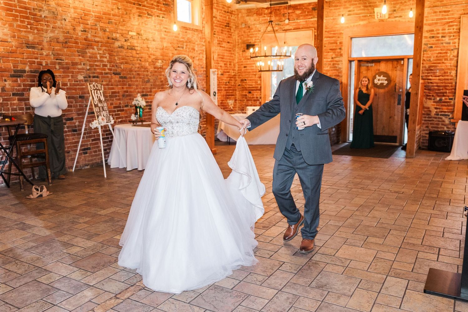 Couple dancing together in a rustic brick venue during their wedding celebration.