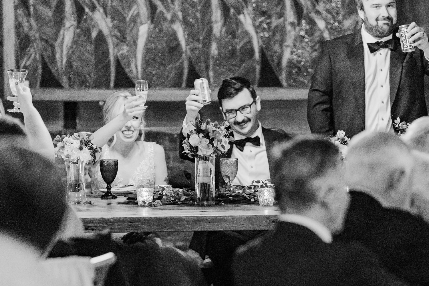 Black and white candid photo of wedding reception celebration.