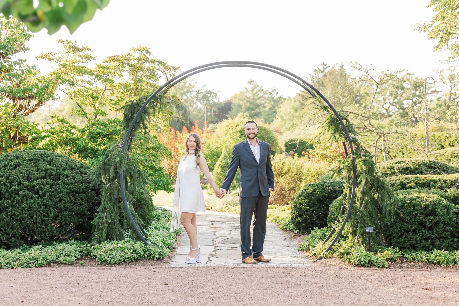 Couple posing beneath garden arch during engagement photos at Cantigny Park in Wheaton, Illinois
