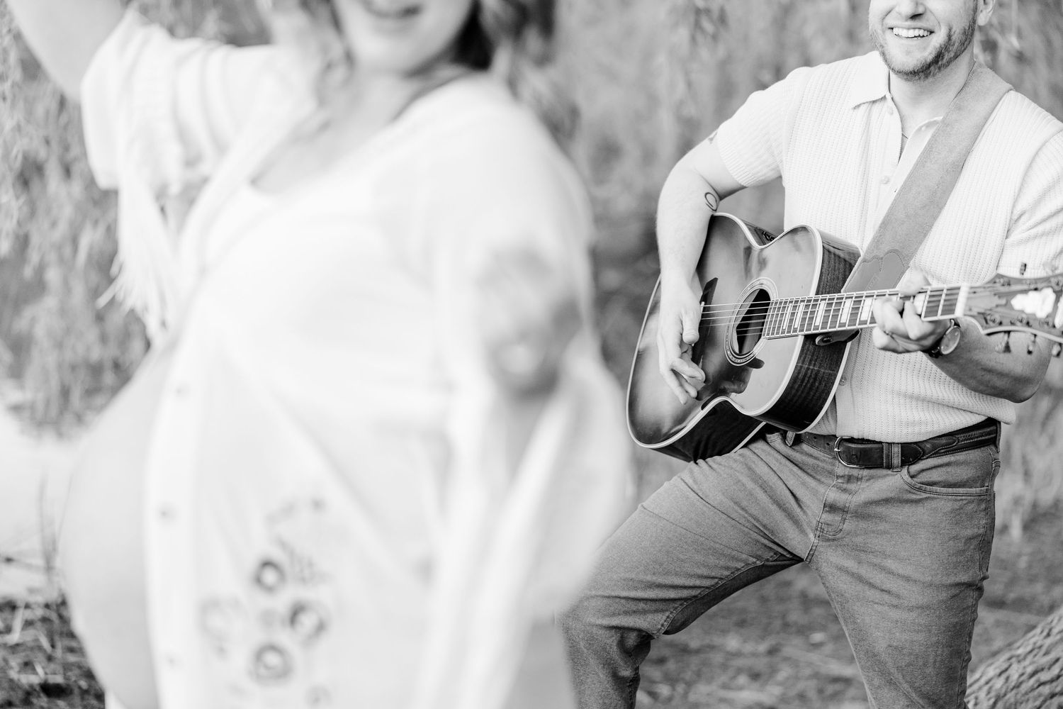 Black and white music-inspired maternity photo with baby bump and guitar at Veterans Acres in Crystal Lake.