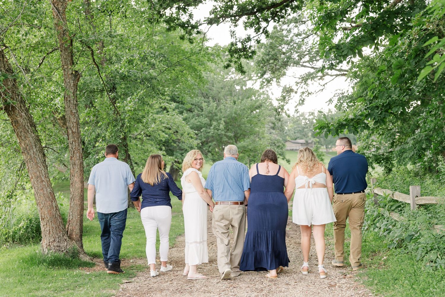 Extended family walking together through the trees during a summer session at Veterans Acres Nature Center in Crystal Lake