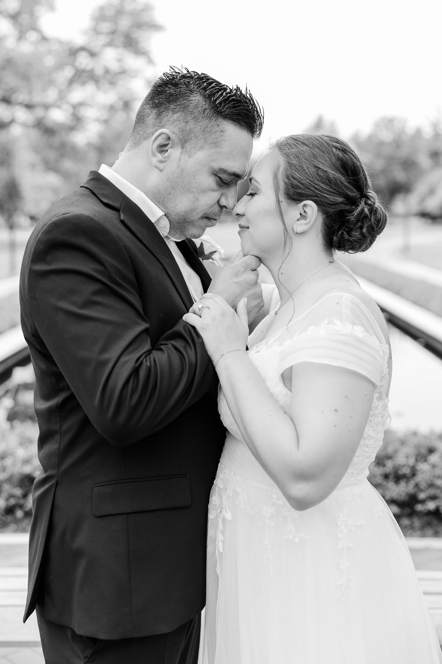 Black-and-white portrait of Monika and Rafael touching foreheads during their Cantigny Park wedding session.