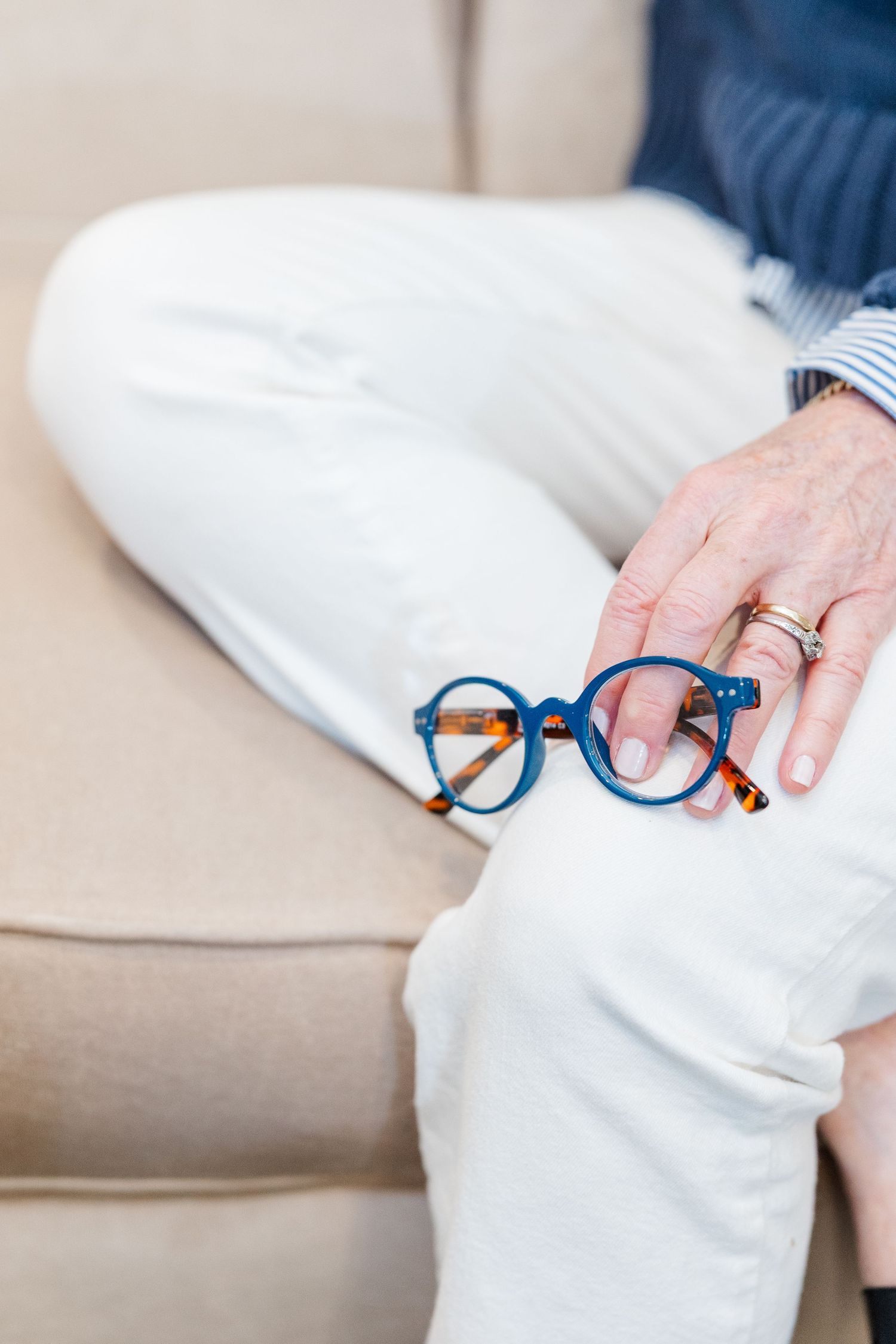 Beacon Hill senior living branding photo in Lombard, Illinois featuring eyeglasses resting on resident’s lap