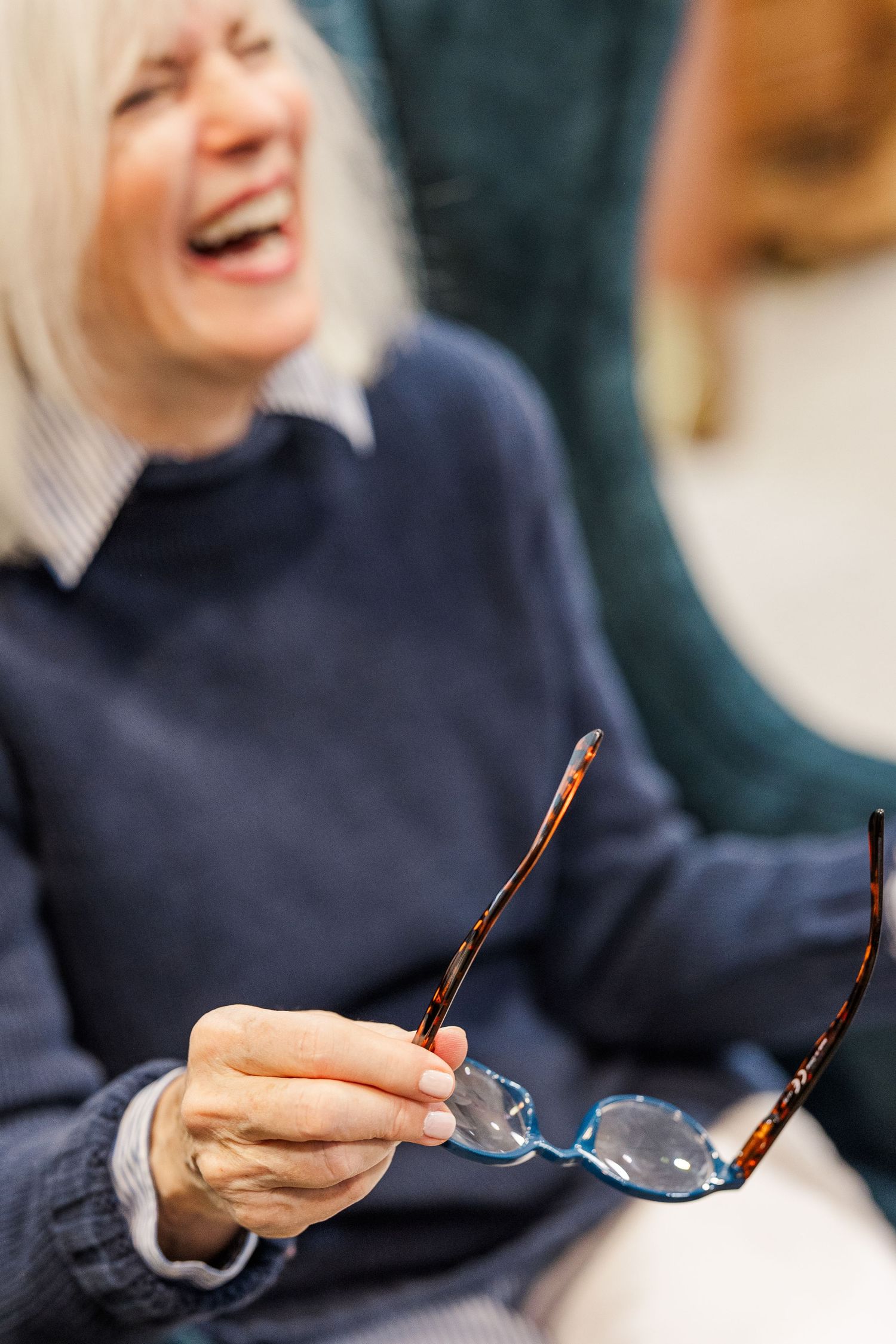 Beacon Hill senior living branding photo in Lombard, Illinois featuring resident holding eyeglasses