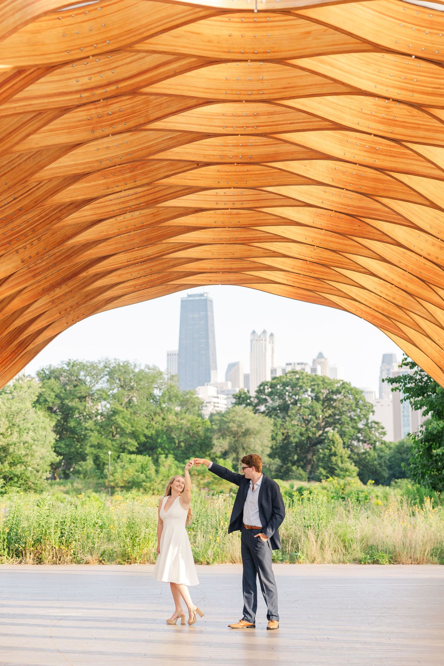 Elizabeth and Joe standing under the Honeycomb Pavilion in Lincoln Park, Chicago, dancing with each other
