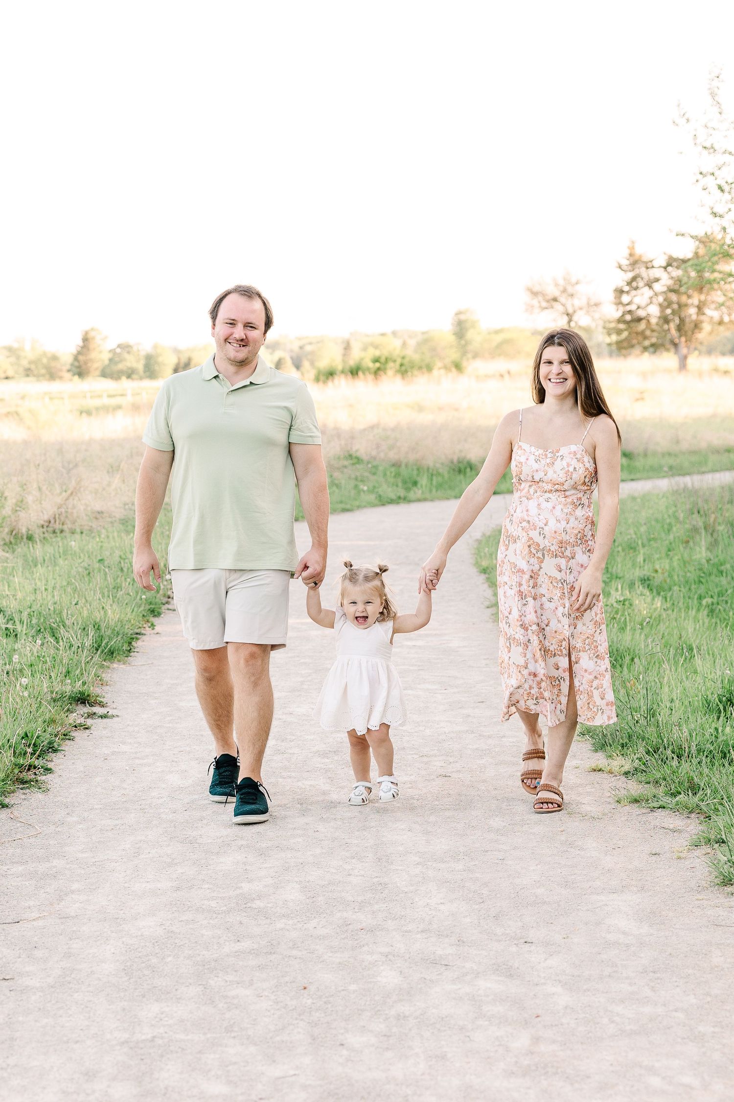 Family of three taking a stroll together on a peaceful walking path.