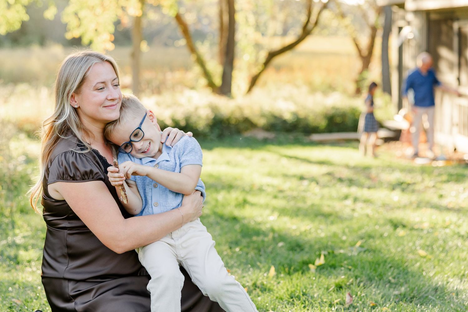 Mom cuddling her son on her lap during relaxed backyard family photos in St. Charles, IL.