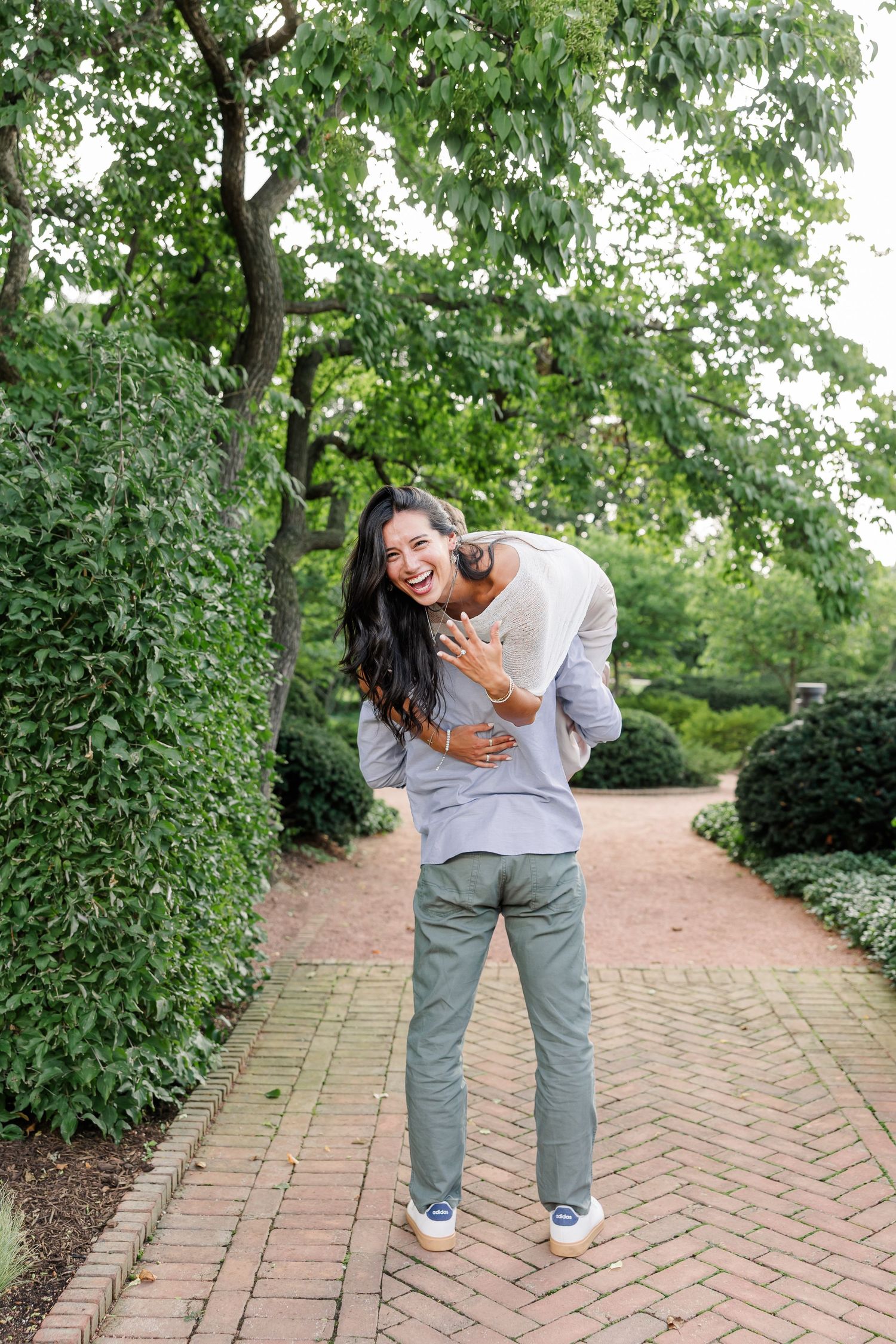 Jack gives Alysia a piggyback ride as they laugh during their Cantigny Park engagement portraits.