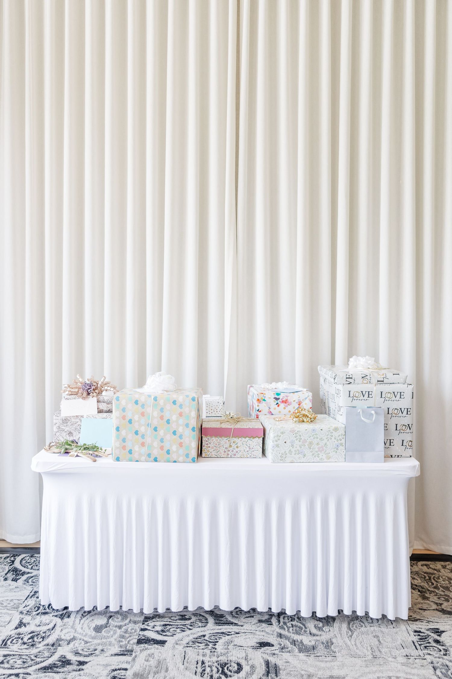 White linen gift table set up for wildflower bridal shower reception