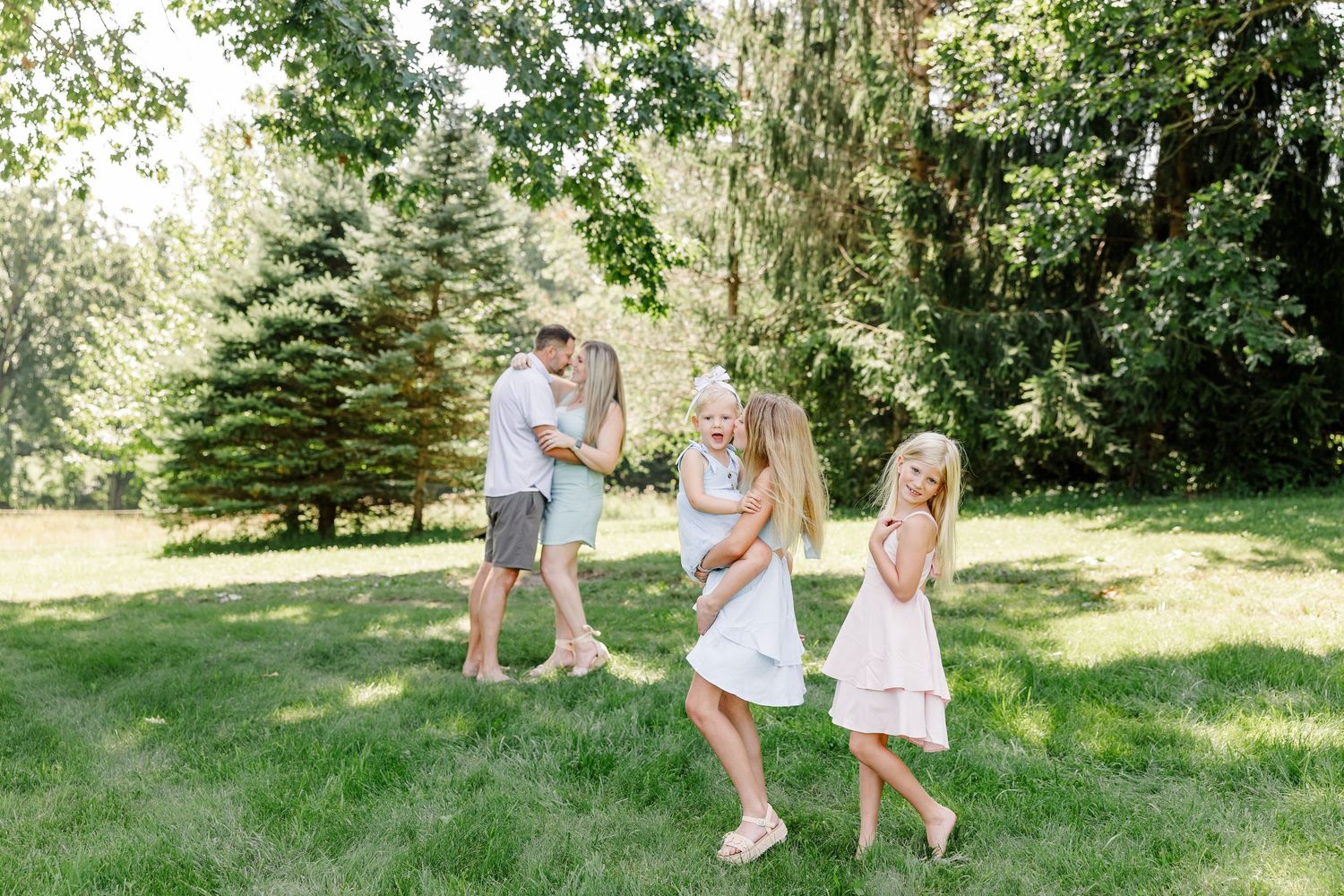 Little girls running ahead of their parents during a playful family session in Crystal Lake, Illinois.