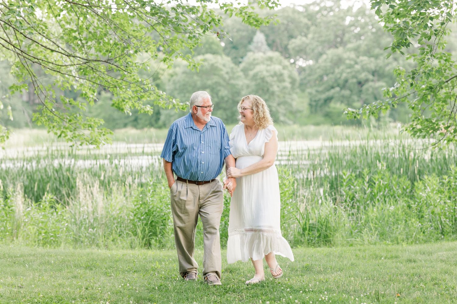 Grandparents walking together through summer greenery during an extended family session at Veterans Acres Nature Center in Crystal Lake