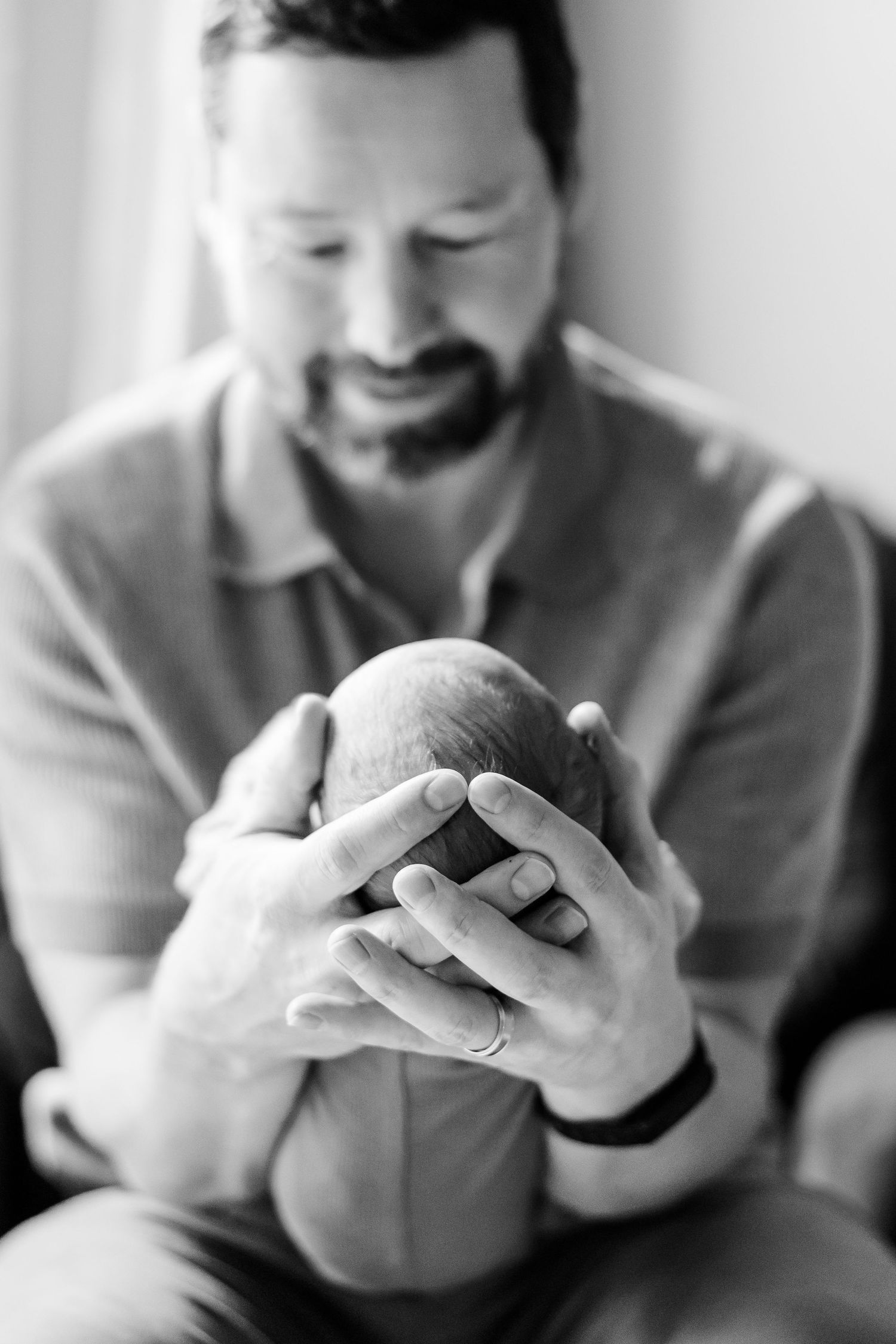 Black and white portrait of father holding newborn during Crystal Lake lifestyle newborn session