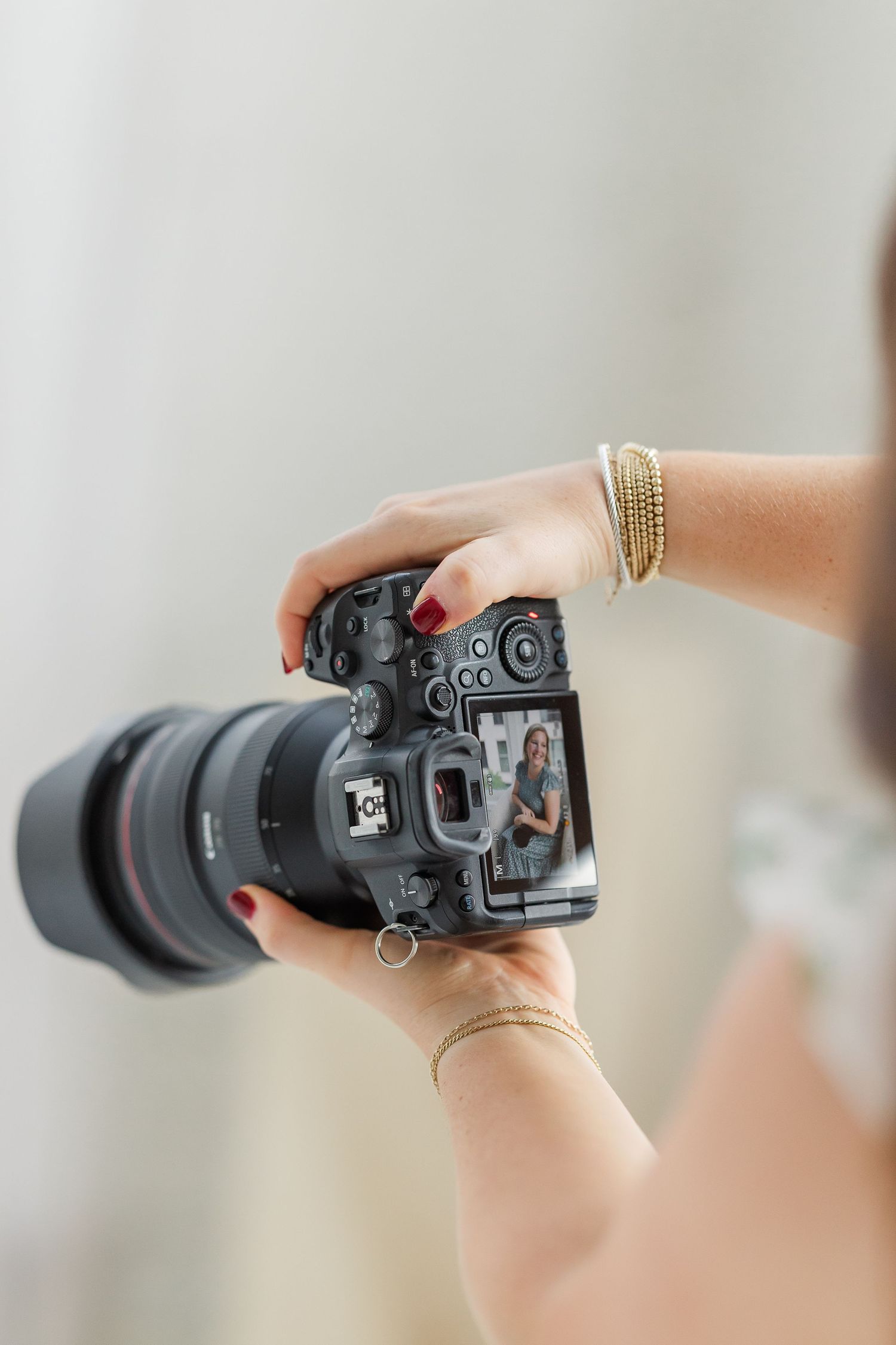 Close-up of Cassie Lacina holding a professional camera during a wedding day